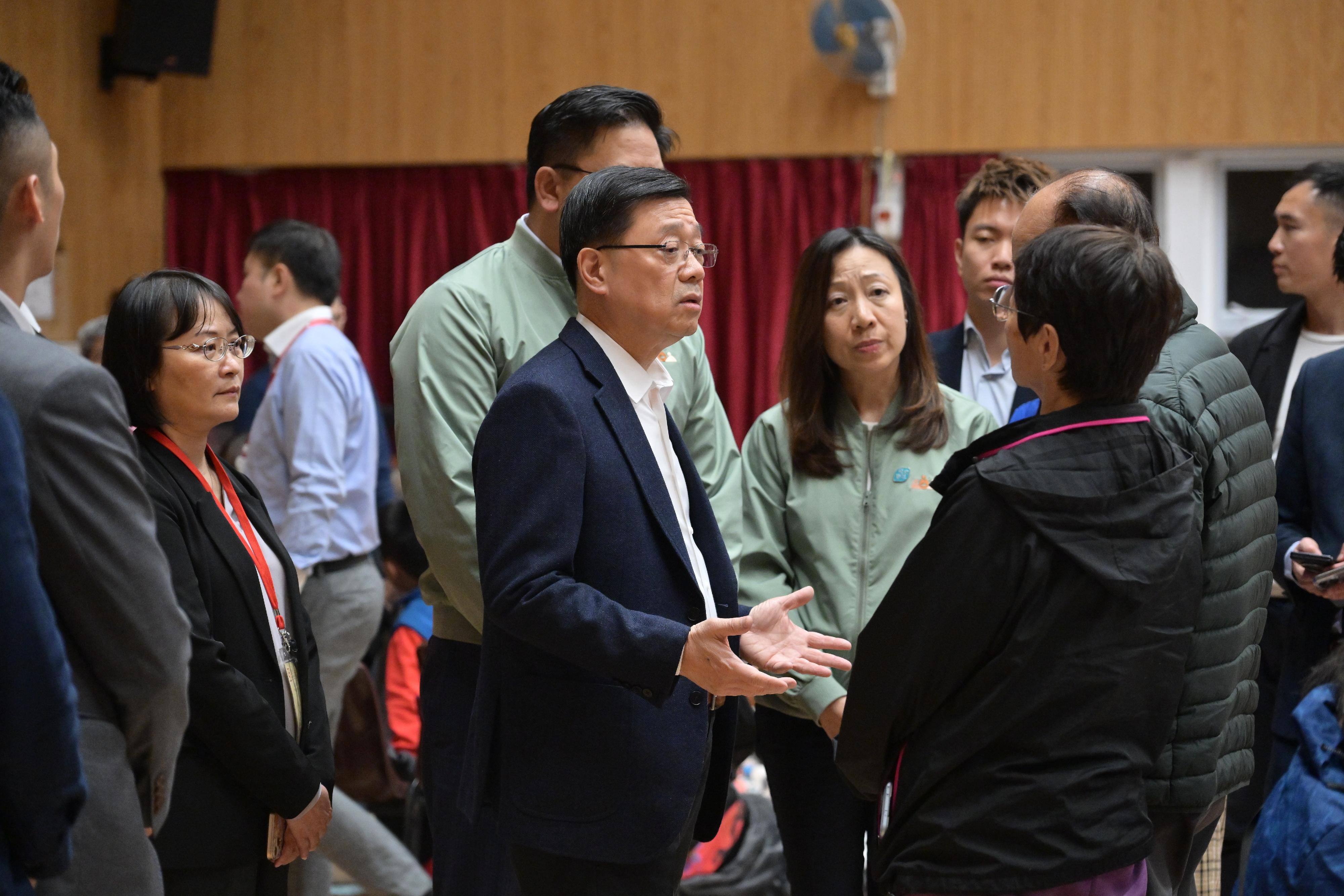 行政長官李家超(中)今日(十一月二十六日)前往臨時庇護中心探望大埔宏福苑五級火警受影響居民。
