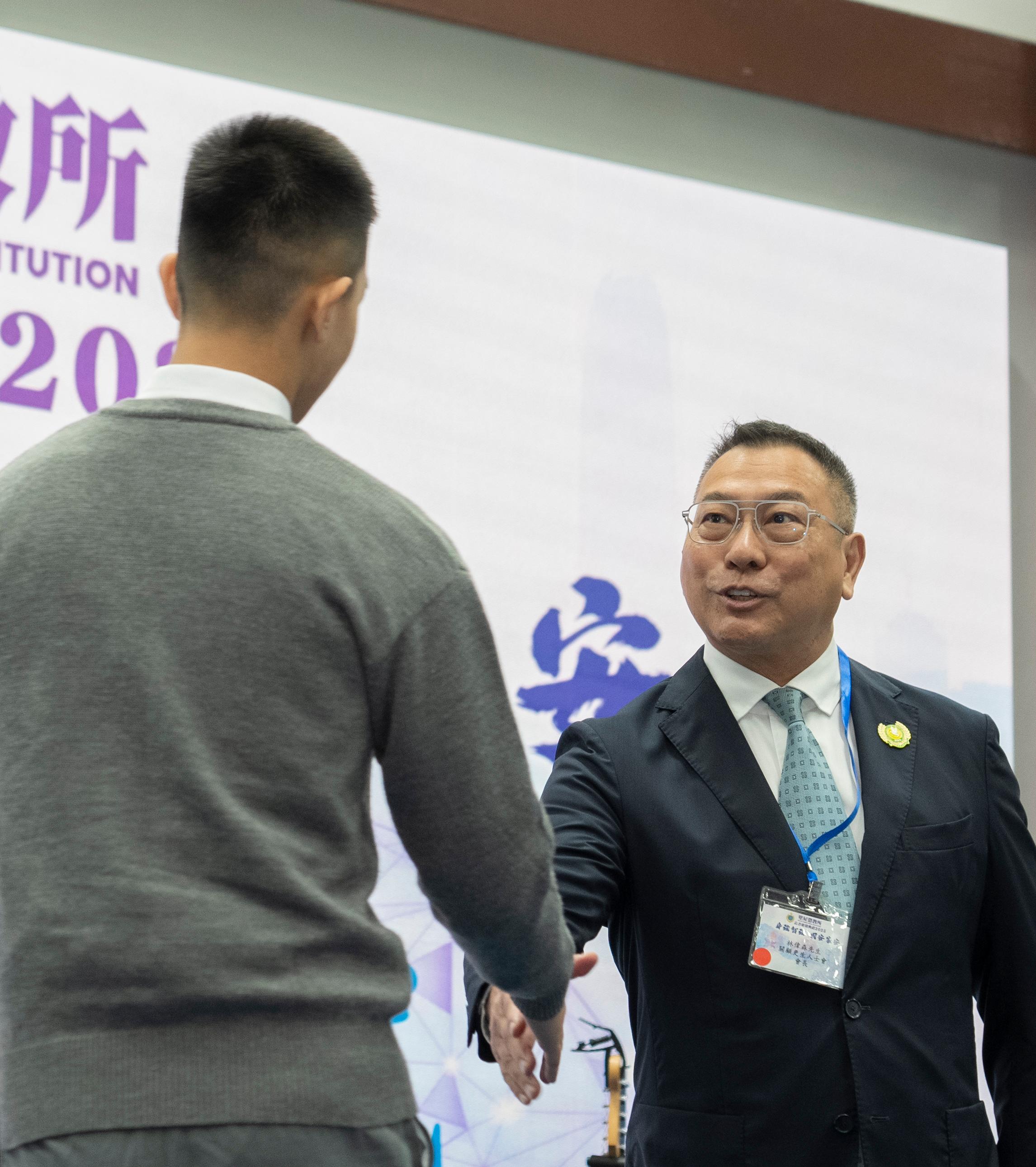 懲教署轄下壁屋懲教所今日（十二月三日）舉行證書頒發儀式，頒發證書予青少年在囚人士，以肯定他們在學業及職業訓練考試上付出的努力及取得的成果。圖示關顧更生人士會會長林偉森頒發證書予青少年在囚人士。