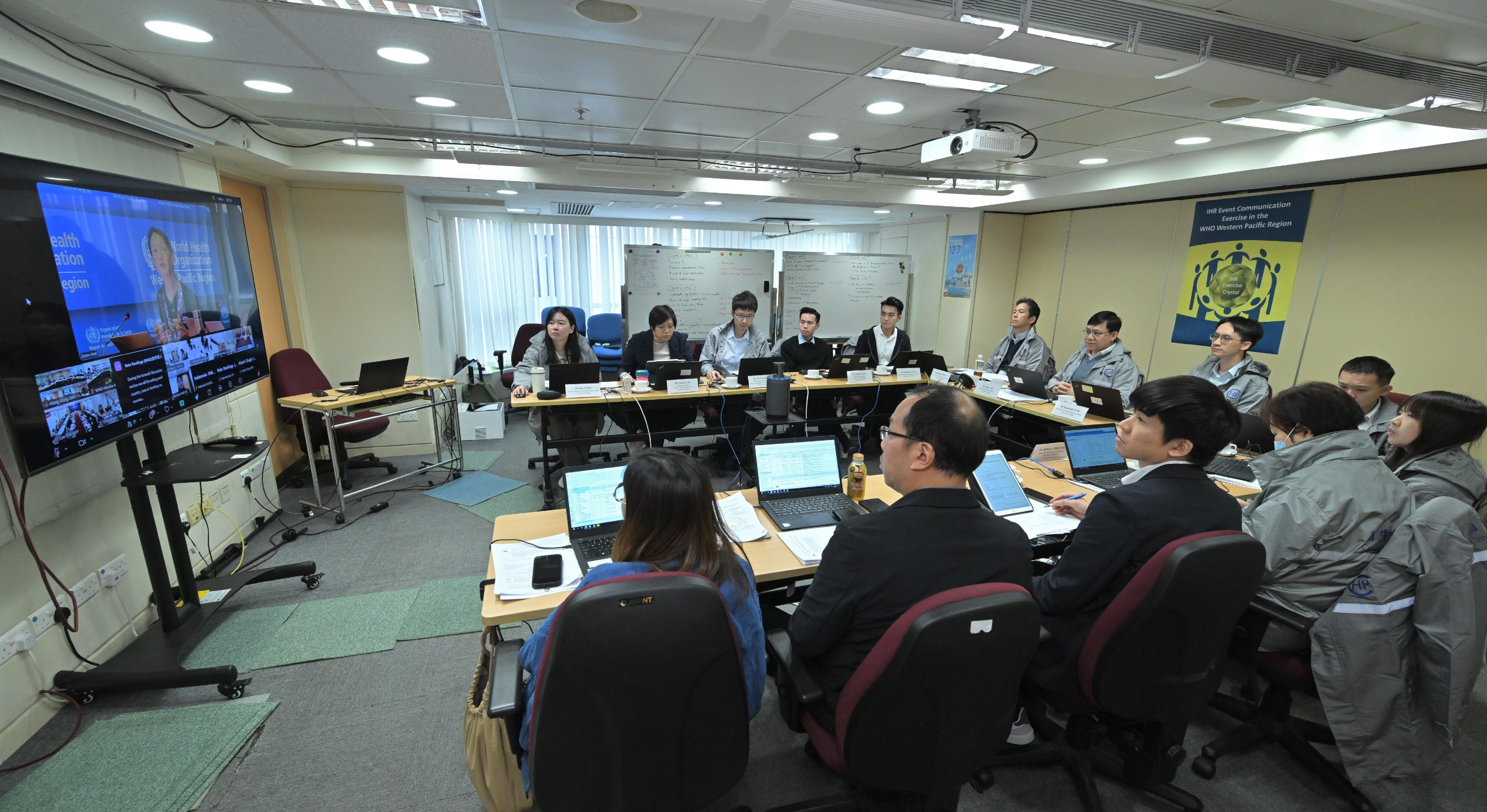 The Department of Health (DH) today (December 3), together with the Food and Environmental Hygiene Department and the Agriculture, Fisheries and Conservation Department, participated in a large-scale annual table-top exercise, Exercise Crystal, organised by the Regional Office for the Western Pacific (WPRO) of the World Health Organization. The exercise aims to enhance emergency response mechanisms and cross-sectoral collaboration capabilities between Hong Kong, China and neighbouring regions to jointly tackle public health emergencies. Photo shows the Head of the Communicable Disease Branch, Centre for Health Protection (CHP) of the DH, Dr Albert Au (seventh left), and other CHP staff participating in the exercise at the debriefing session led by the WPRO exercise host to review the achievements of the exercise through telecommunications. 