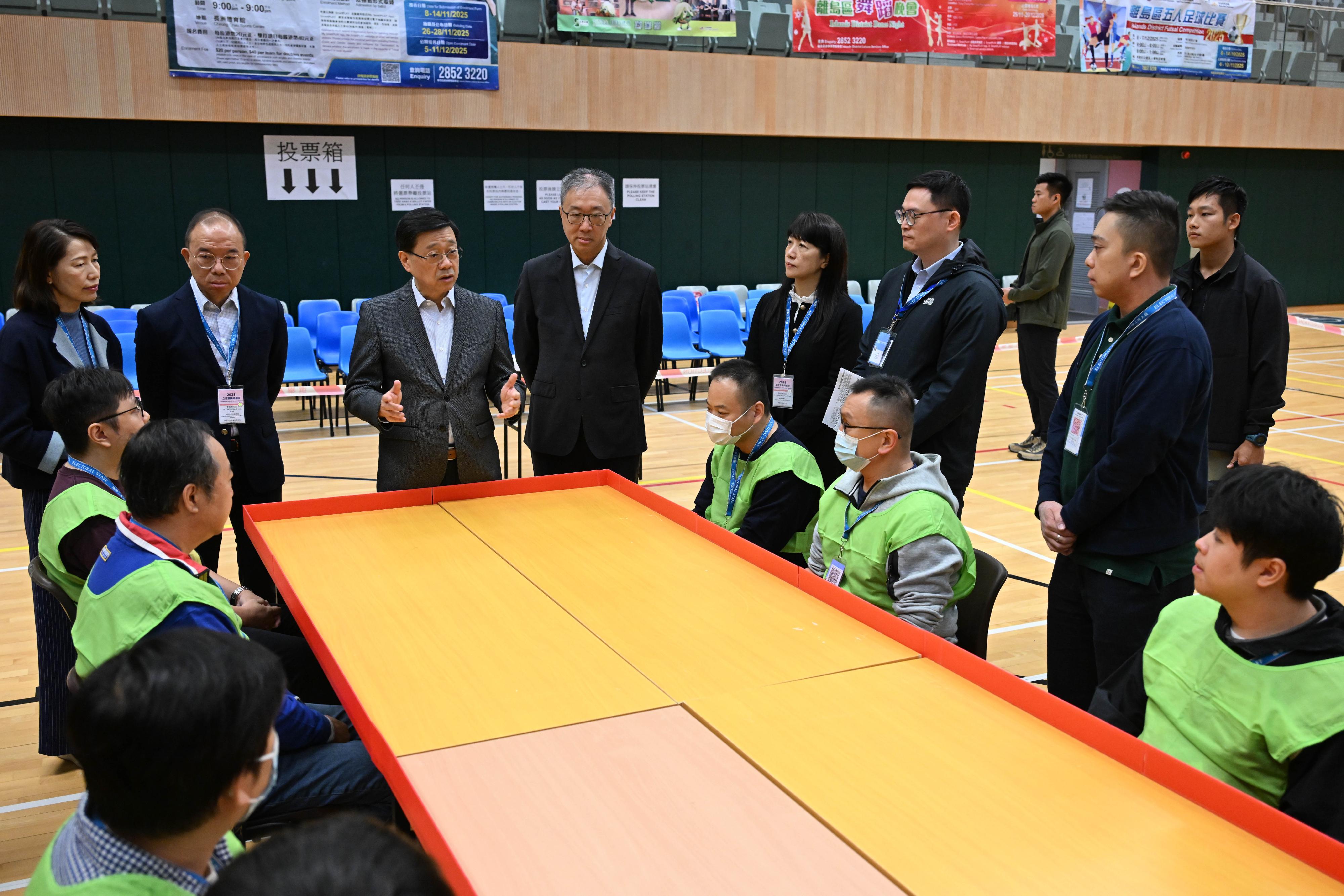 選舉管理委員會主席陸啟康法官(左四)今日(十二月六日)上午與政制及內地事務局局長曾國衞(左二)、行政長官辦公室主任葉文娟(左一)及選舉事務處總選舉事務主任陳淑華(左五),陪同行政長官李家超(左三)視察設於東涌文東路體育館的二○二五年立法會換屆選舉一般投票站,了解場地佈置及運作綵排等的最後準備情況。