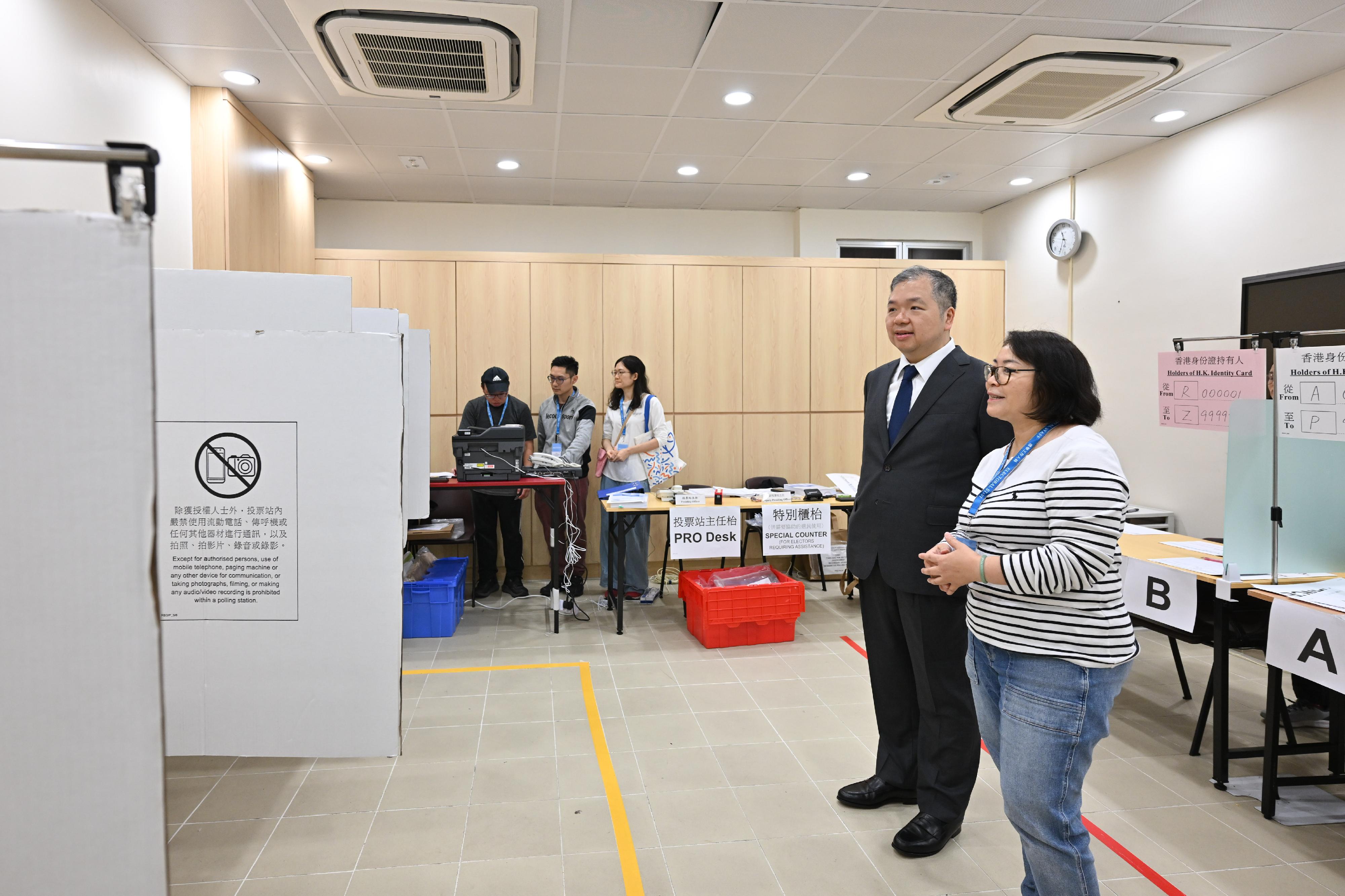 選舉管理委員會委員文本立資深大律師(左)今日(十二月六日)上午巡視設於鄧肇堅維多利亞官立中學的二○二五年立法會換屆選舉少數族裔人士專屬投票站,實地視察選舉工作人員的預備工作。