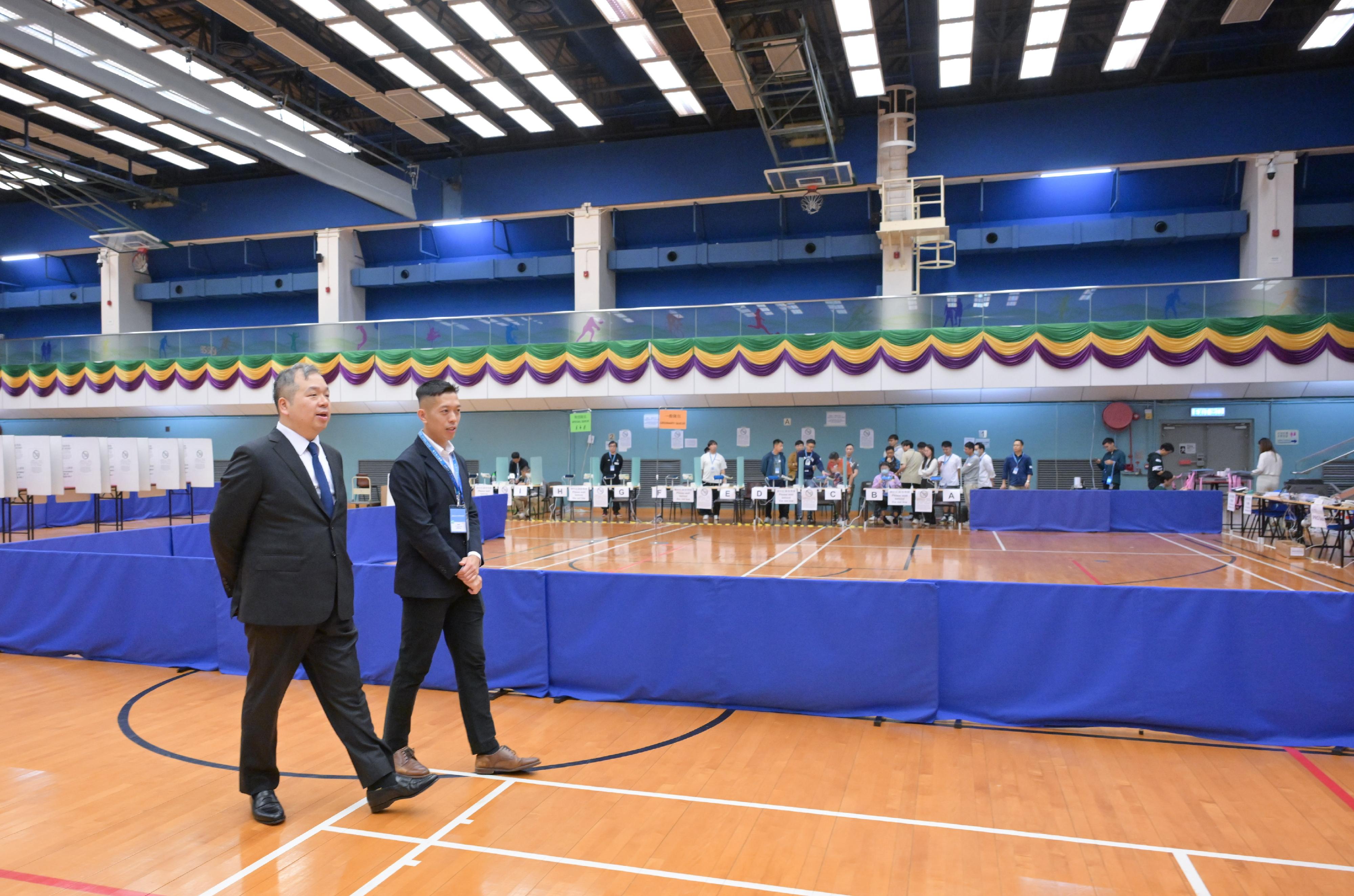 Electoral Affairs Commission member Mr Bernard Man, SC (left), visits the Ordinary Polling Station of the 2025 Legislative Council General Election at Lai Chi Kok Sports Centre this morning (December 6) to inspect the preparatory work of the electoral staff.