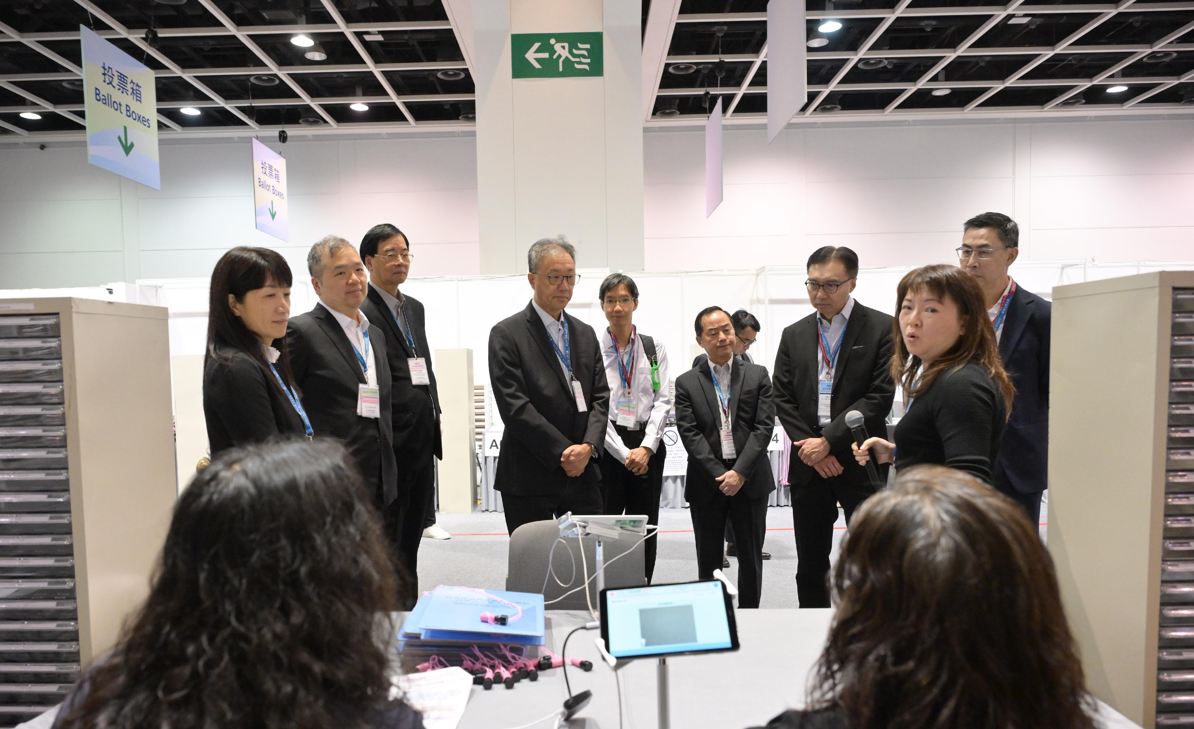 The Chairman of the Electoral Affairs Commission (EAC), Mr Justice David Lok (fourth left), EAC members Professor Daniel Shek (third left) and Mr Bernard Man, SC (second left), this afternoon (December 6) visit the polling station of the Election Committee constituency at the Hong Kong Convention and Exhibition Centre in the company of the Commissioner for Digital Policy, Mr Tony Wong (fourth right); the Convenor of the Technical Advisory Committee (TAC), Mr Sunny Lee (third right); TAC members Mr Wilson Wong (first right) and Mr Raymond Wong (centre); and the Chief Electoral Officer of the Registration and Electoral Office, Ms Natalie Chan (first left), to inspect the on-site drill conducted by staff members to ensure a smooth operation of the electoral work.