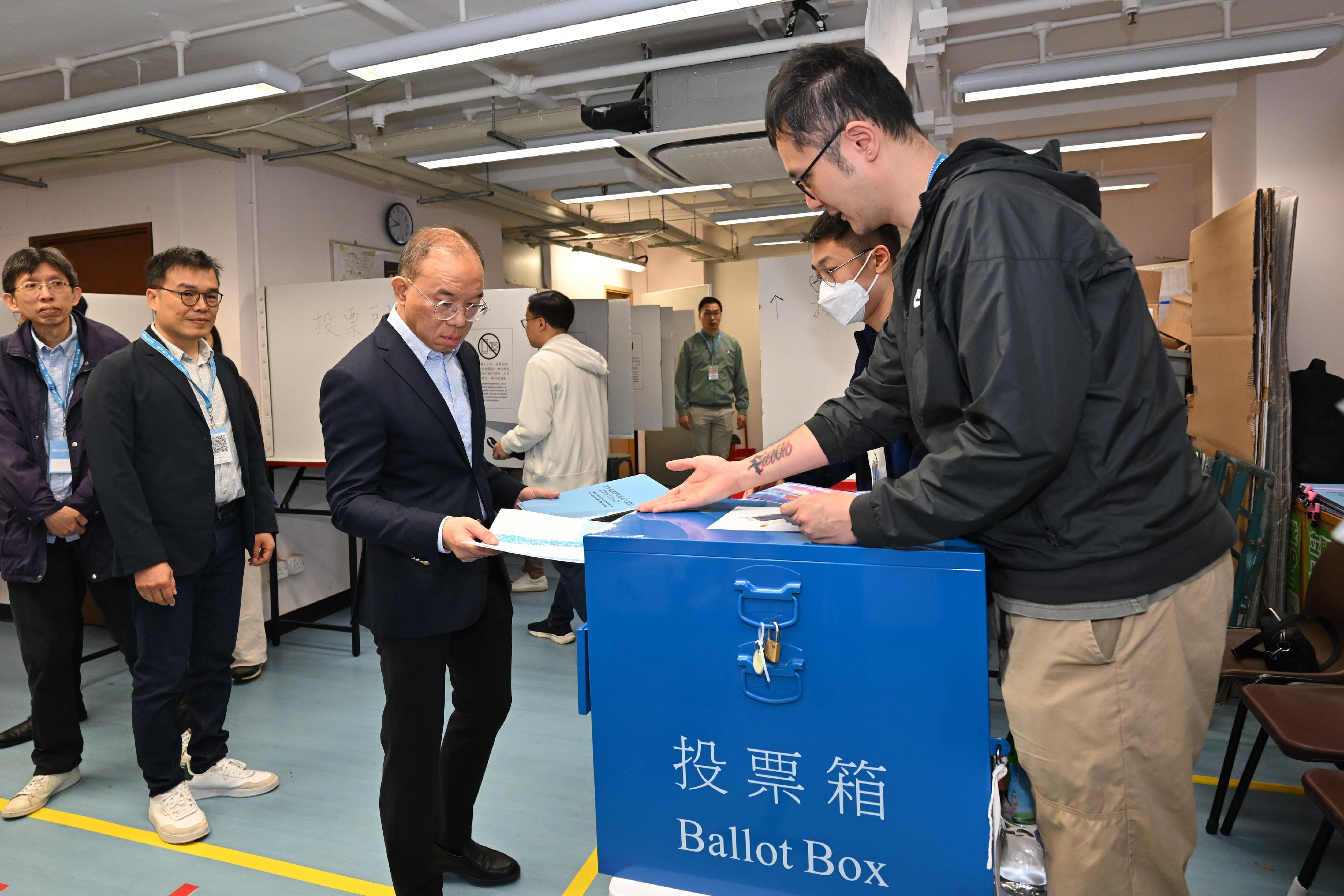 政制及内地事务局局长曾国卫（左三）今日（十二月七日）在东区少年警讯会所投票站为二○二五年立法会换届选举投票。
