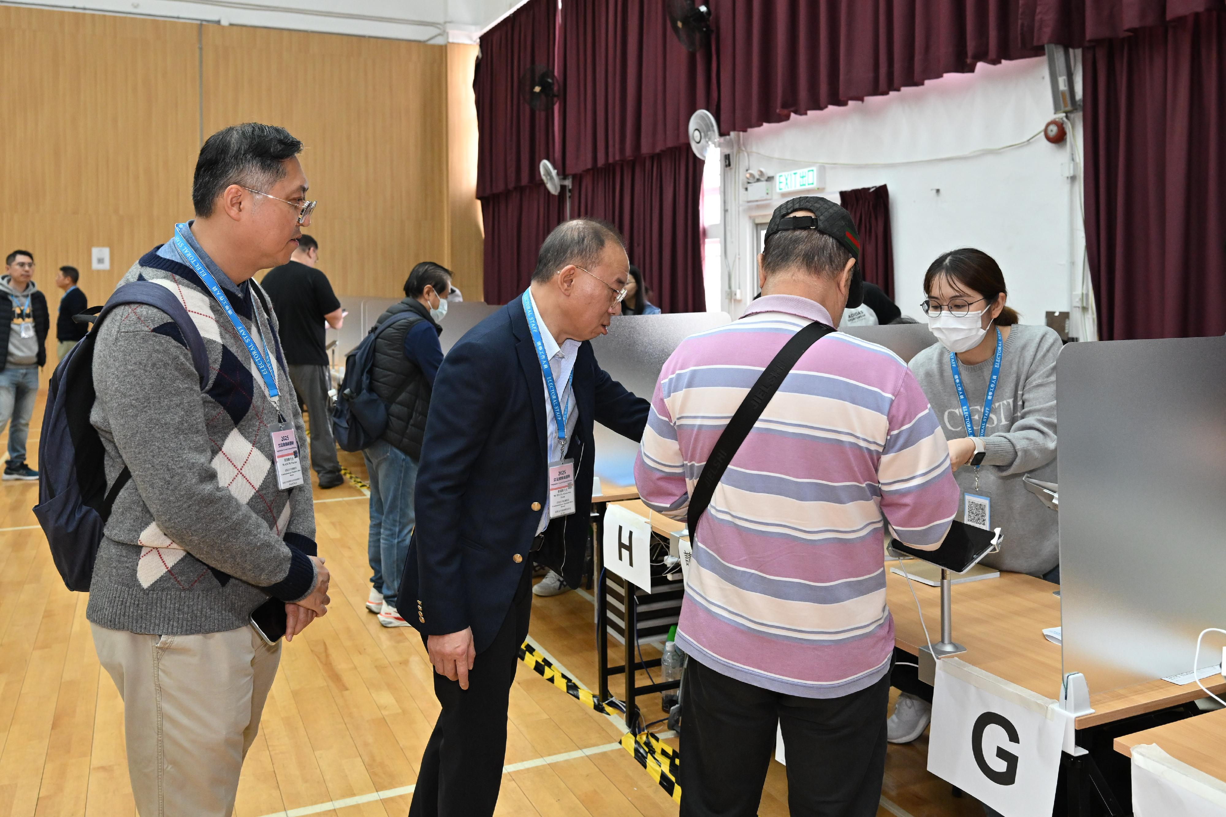 政制及内地事务局局长曾国卫（右三）今日（十二月七日）在上水巡视二○二五年立法会换届选举位于东华三院甲寅年总理中学（礼堂）的邻近边境投票站。