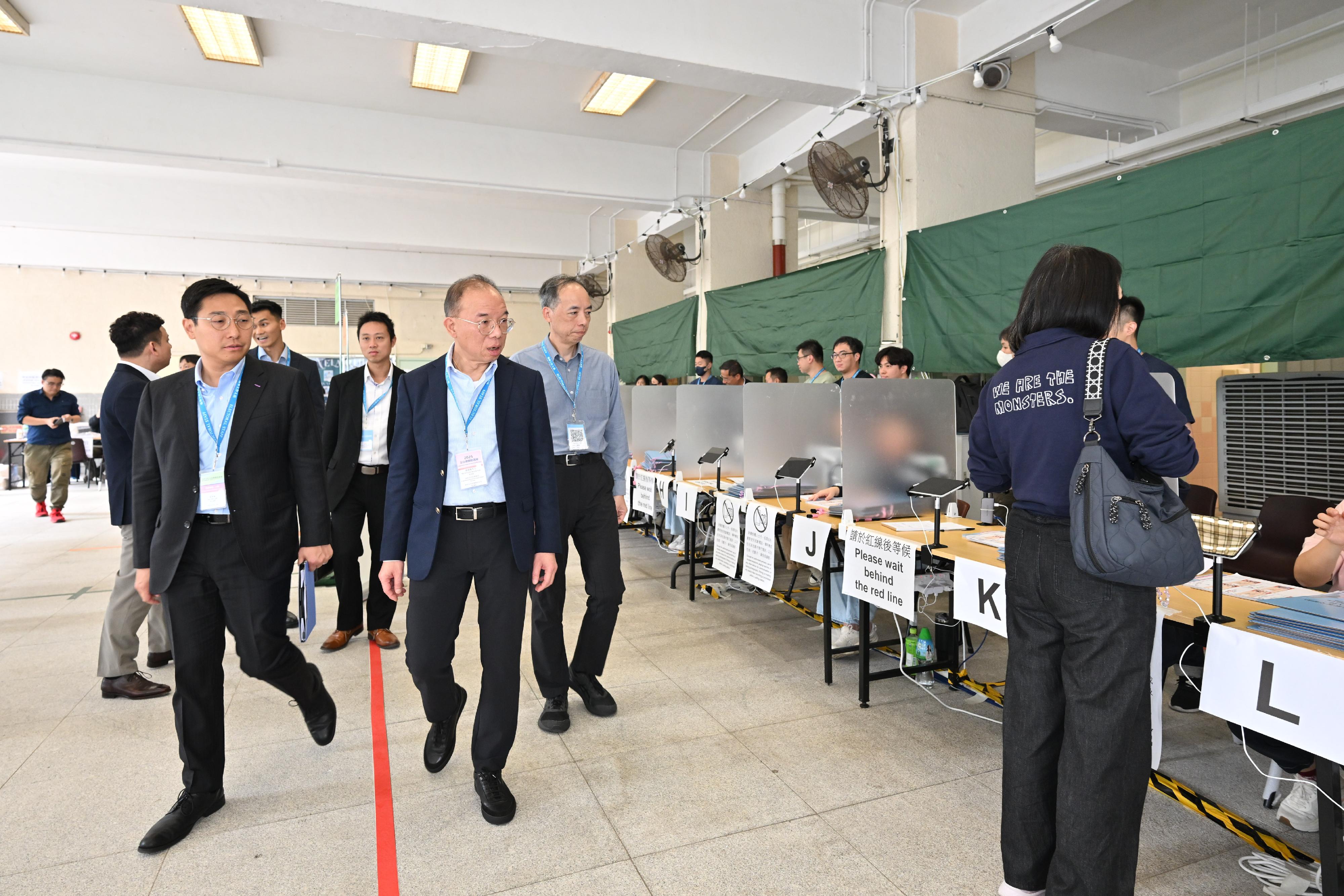 政制及内地事务局局长曾国卫（前排右）今日（十二月七日）前往沙田巡视二○二五年立法会换届选举位于圣罗撒书院的医院管理局医护人员专属投票站。