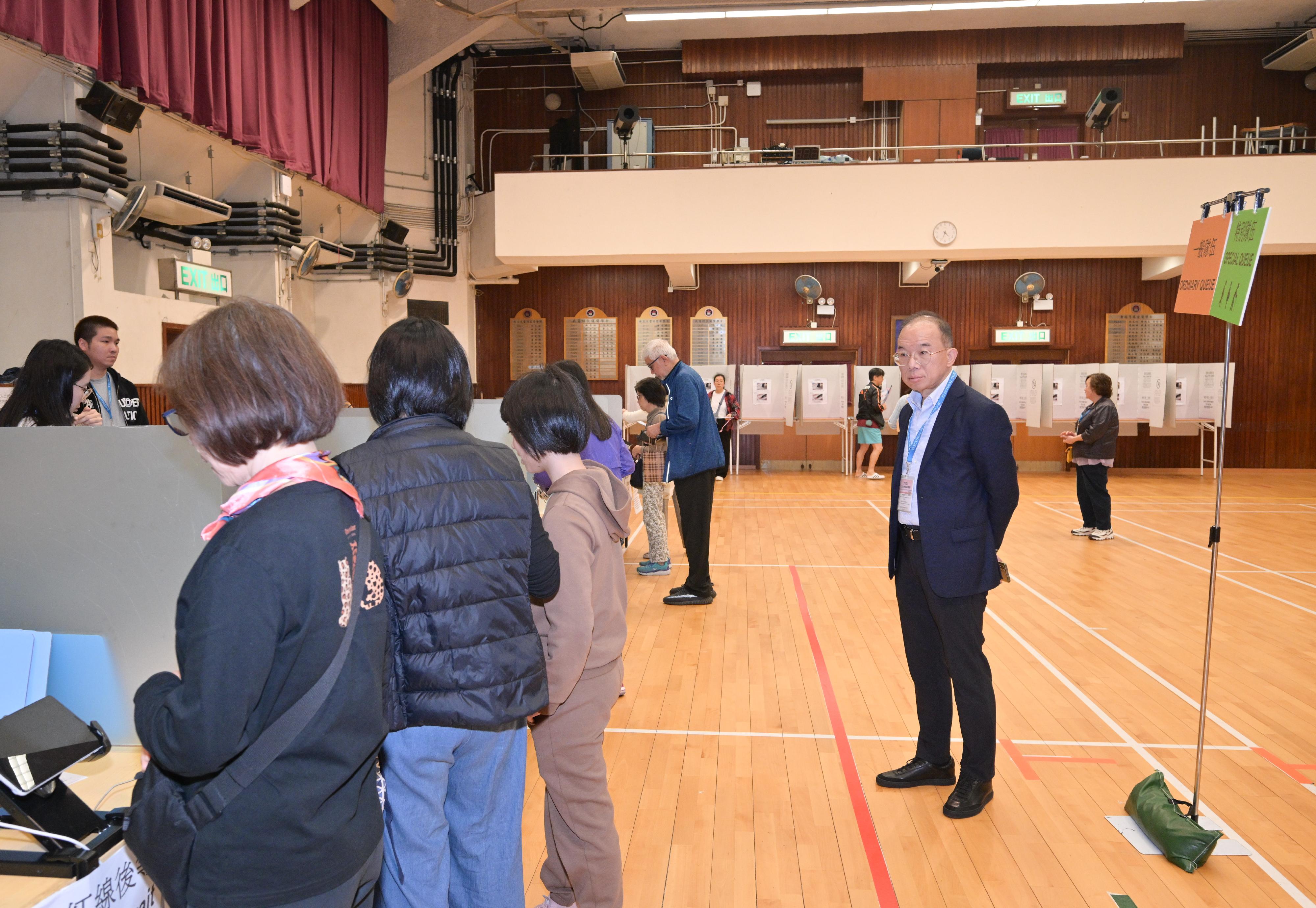 政制及内地事务局局长曾国卫（右一）今日（十二月七日）在北角巡视二○二五年立法会换届选举位于显理中学的一般投票站。