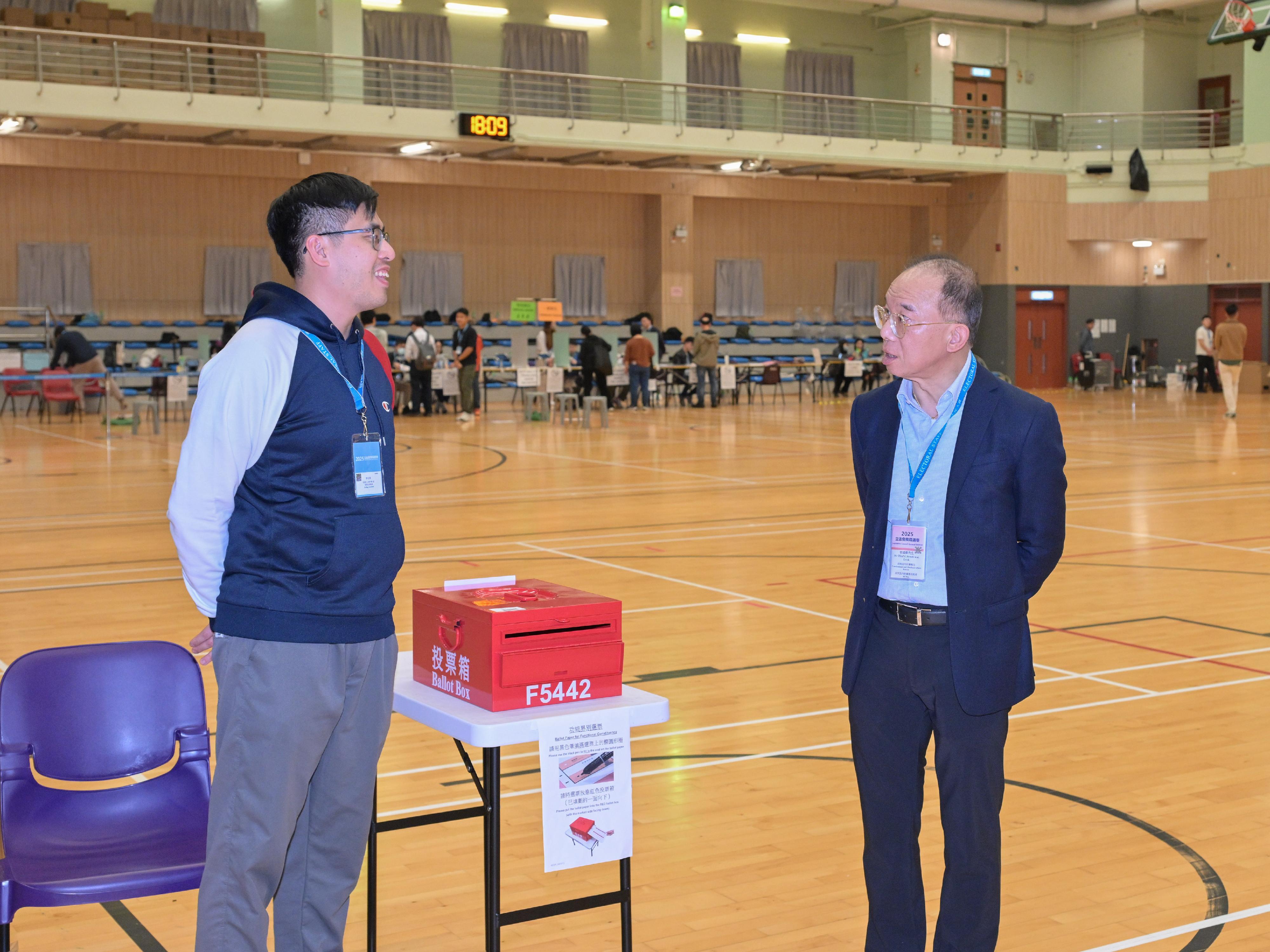 政制及内地事务局局长曾国卫（右）今日（十二月七日）在坚尼地城巡视二○二五年立法会换届选举位于士美非路体育馆的一般投票站。