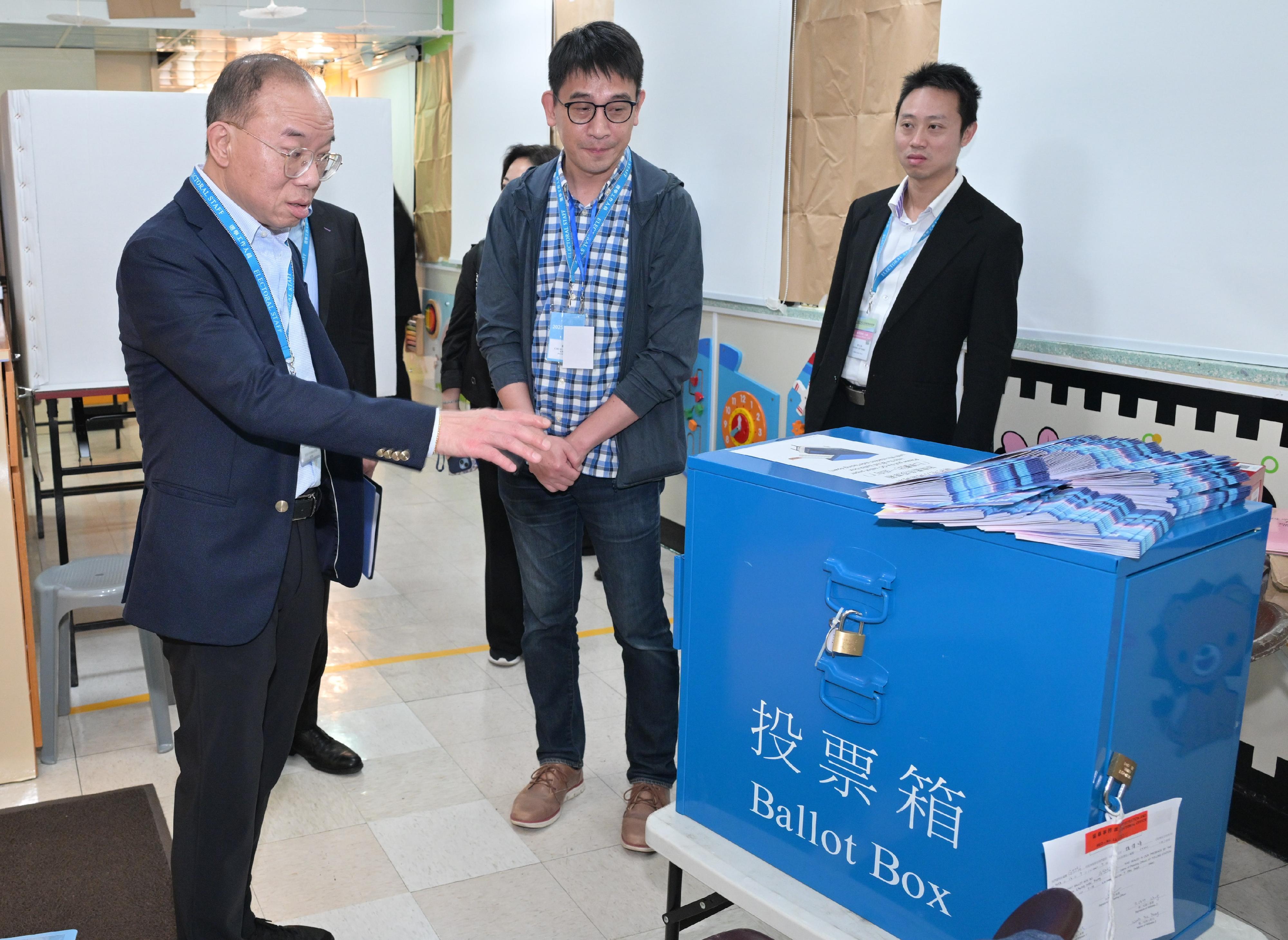 政制及内地事务局局长曾国卫（左一）今日（十二月七日）在东区巡视二○二五年立法会换届选举位于圣安娜中英文幼稚园的一般投票站。