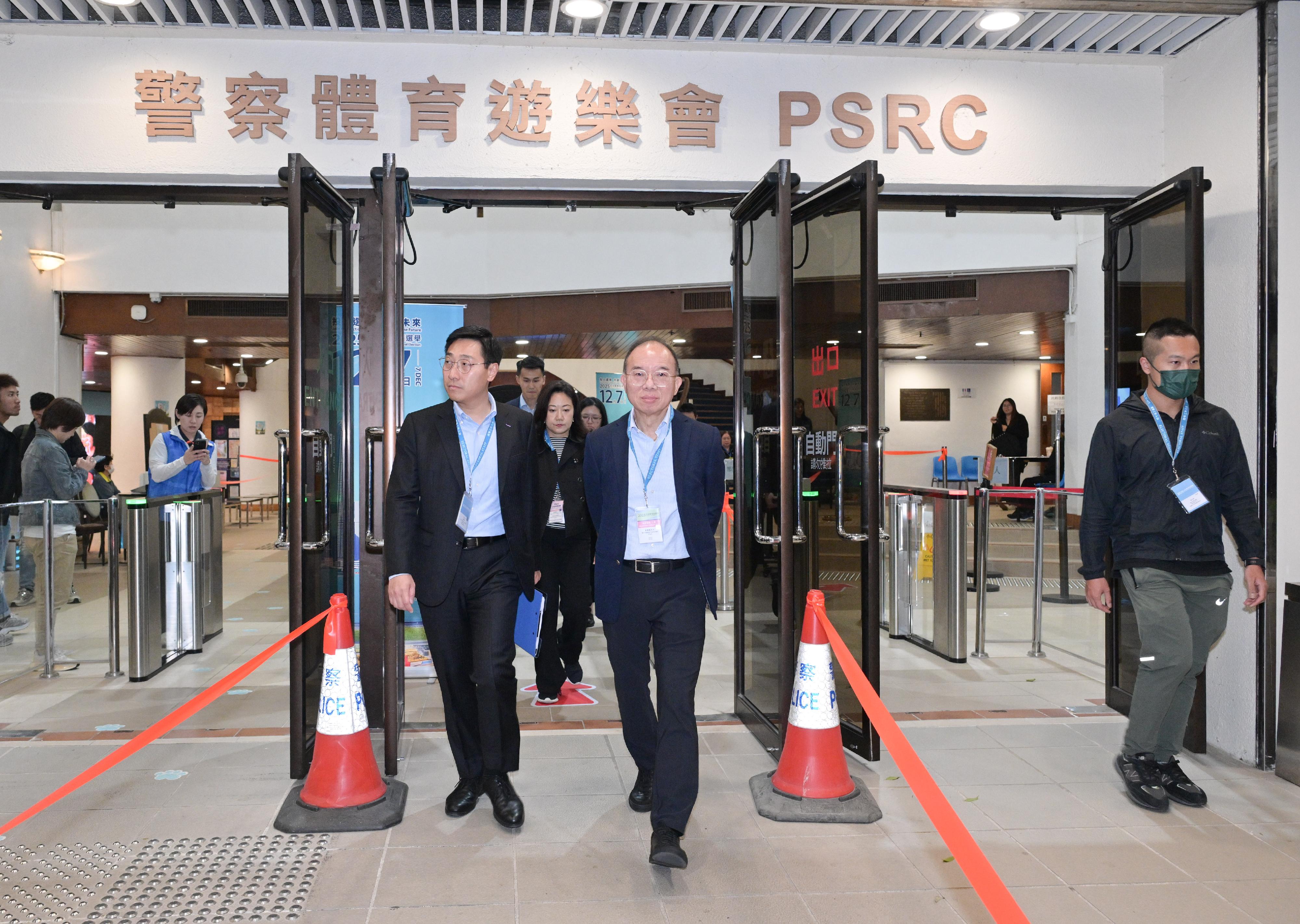 政制及内地事务局局长曾国卫（中）今日（十二月七日）在旺角巡视二○二五年立法会换届选举位于香港警务处警察体育游乐会的专属投票站。