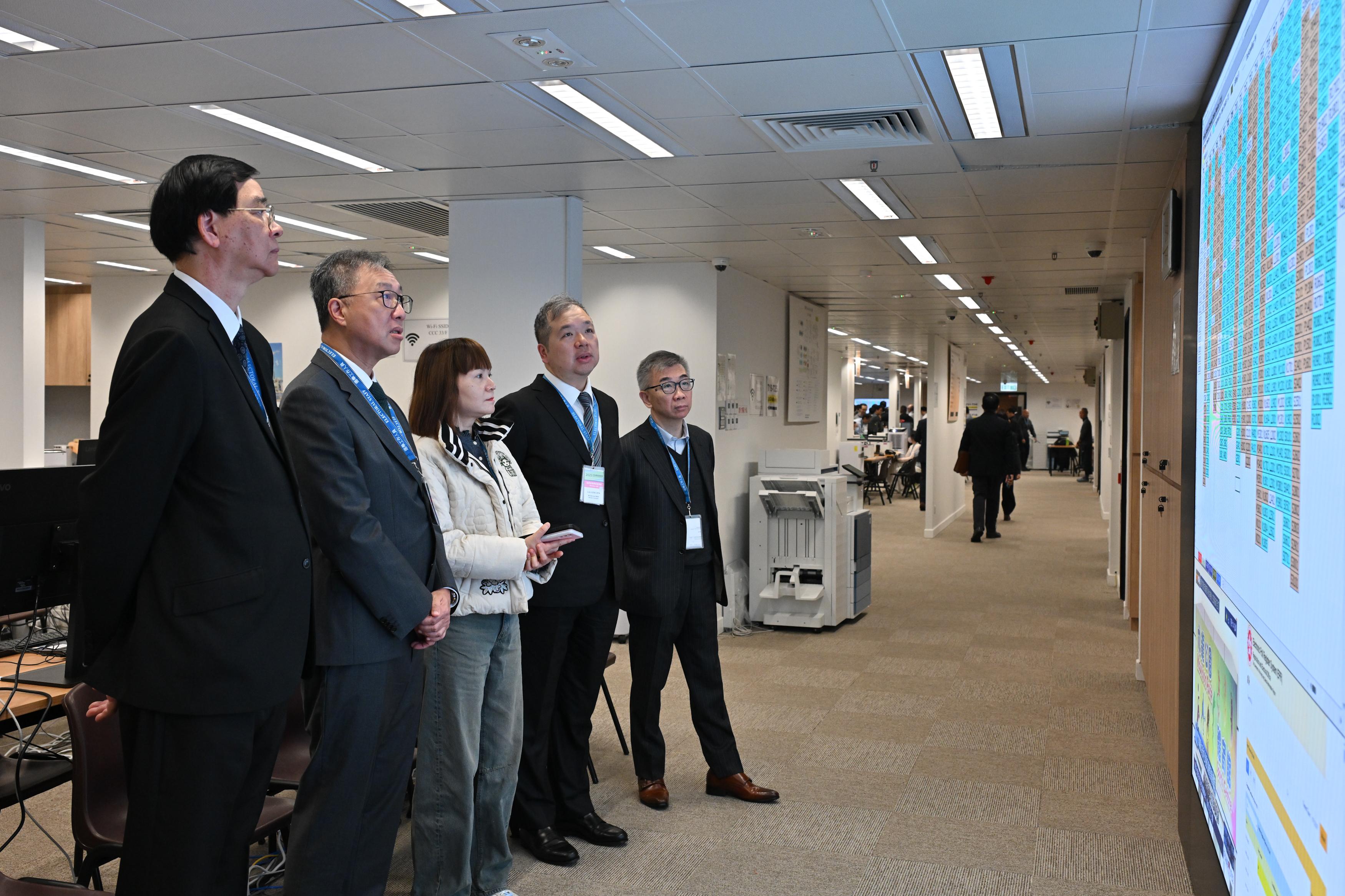 The Chairman of the Electoral Affairs Commission (EAC), Mr Justice David Lok (second left), along with EAC members Professor Daniel Shek (first left) and Mr Bernard Man, SC (second right), and the Acting Permanent Secretary for Constitutional and Mainland Affairs, Ms Maisie Chan (centre), visit the Central Command Centre of the 2025 Legislative Council General Election this morning (December 7).
