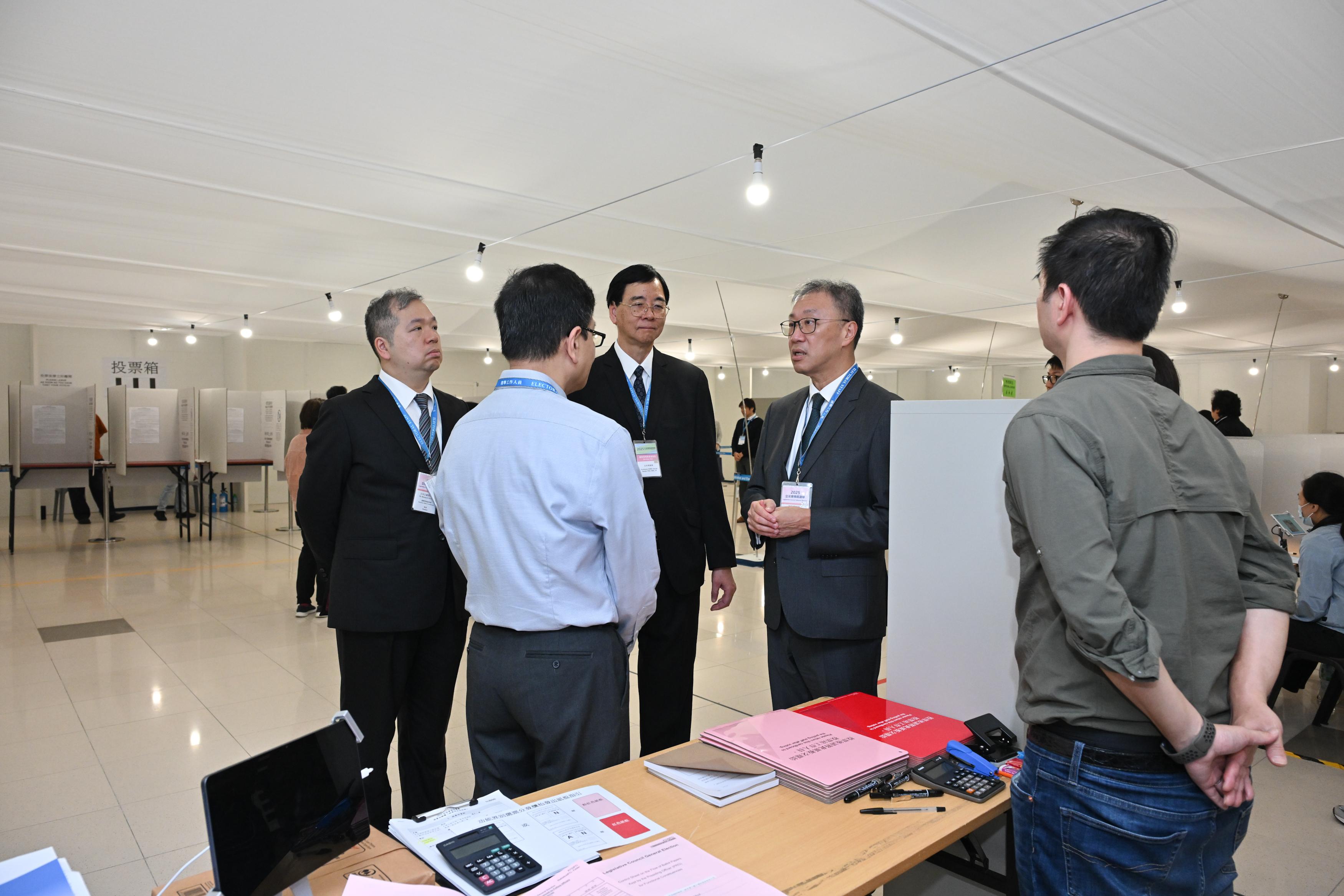 The Chairman of the Electoral Affairs Commission (EAC), Mr Justice David Lok (right), along with EAC members Professor Daniel Shek (centre) and Mr Bernard Man, SC (left), visit the Near Boundary Polling Station of the 2025 Legislative Council General Election at Hong Kong International Airport Terminal 2 this morning (December 7) to inspect the operation of the polling station.