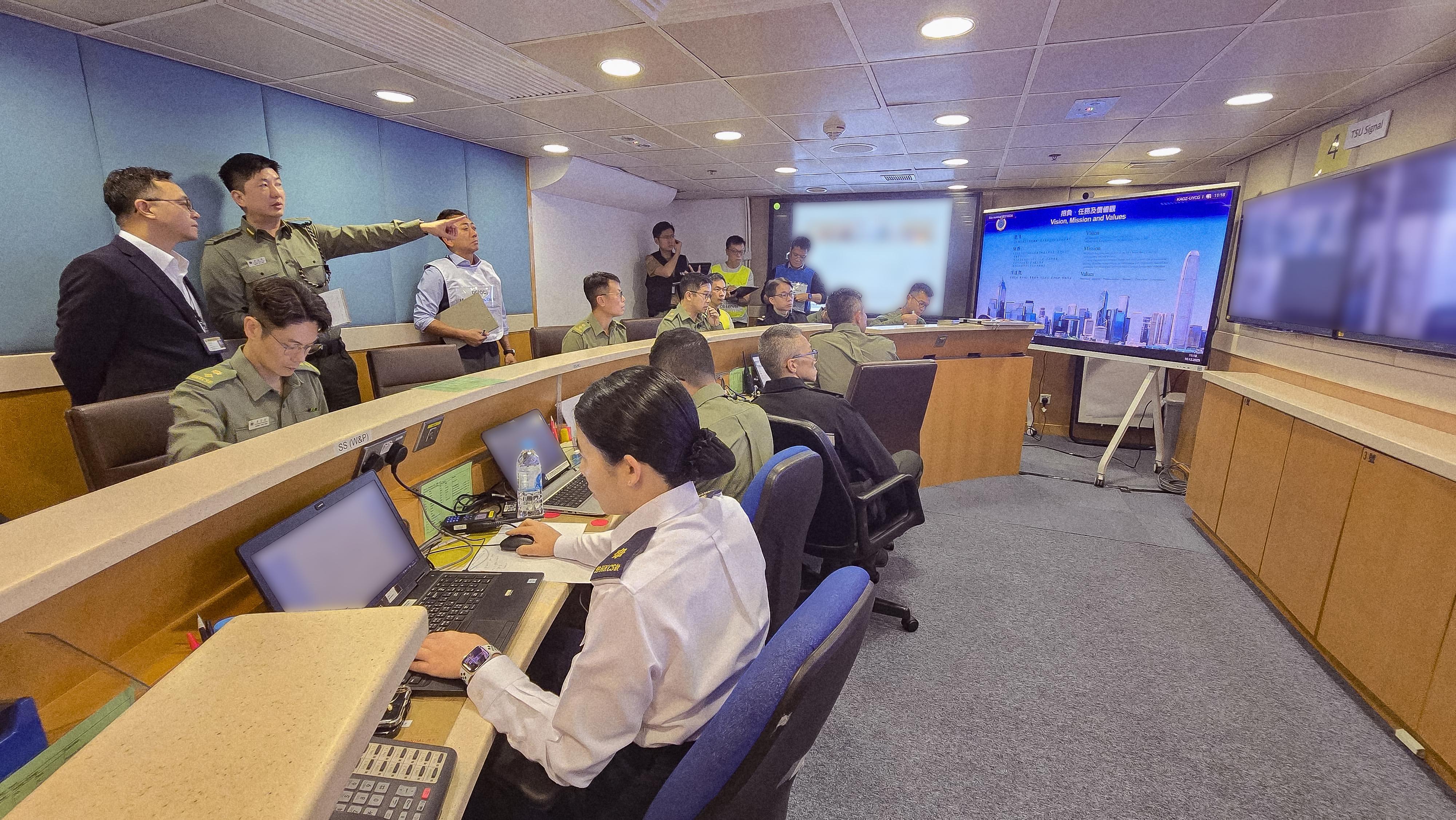 The Correctional Services Department (CSD) conducted a large-scale emergency exercise, code-named "Concord XXIV", at Hei Ling Chau Correctional Institution today (December 10). The exercise simulated a series of incidents, which included mass indiscipline by persons in custody (PICs), a hostage-taking situation, a PIC escape attempt, assaults on CSD staff, a fire and the discovery of explosives. Photo shows the Commissioner of Correctional Services, Mr Wong Kwok-hing (back row, first left), visiting the Department's Central Control Centre in Stanley and being briefed by the Acting Assistant Commissioner of Correctional Services (Operations), Mr Hung Ka-lok (back row, second left), on the operation of the exercise.