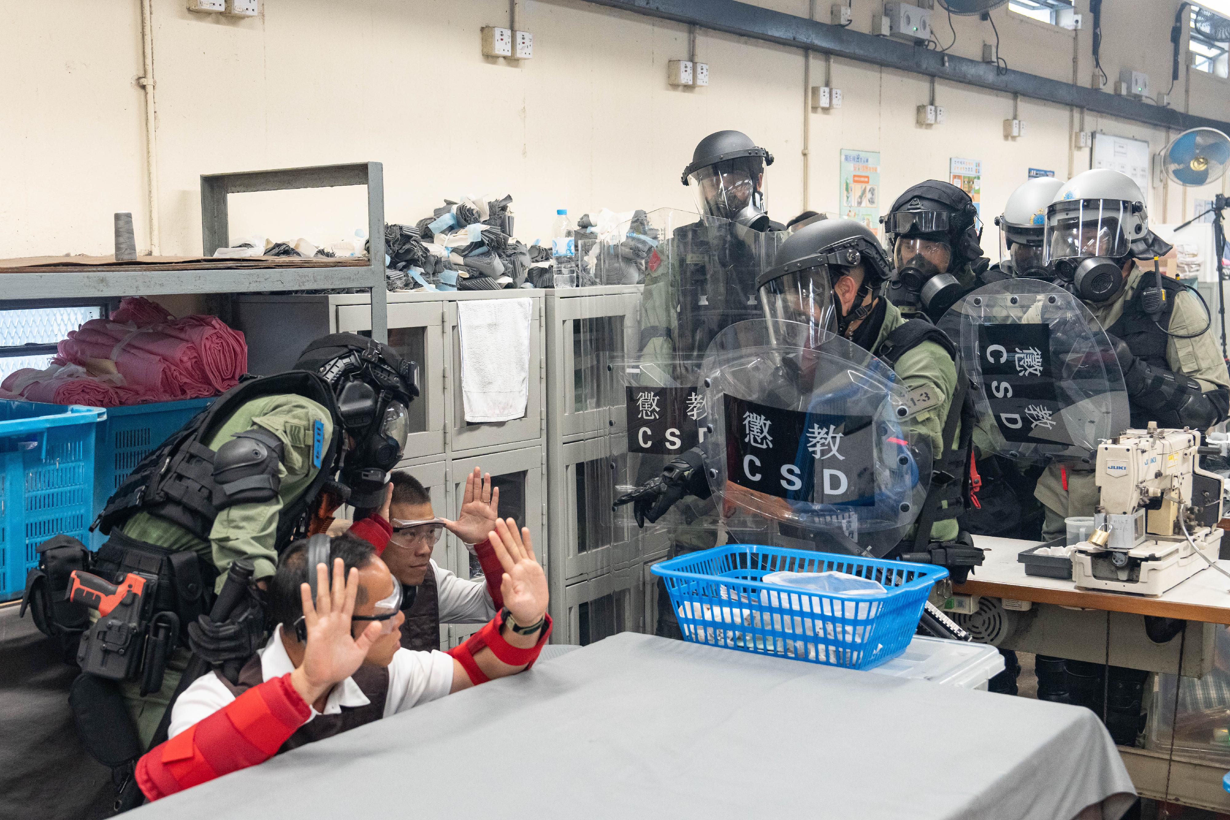 The Correctional Services Department (CSD) conducted a large-scale emergency exercise, code-named "Concord XXIV", at Hei Ling Chau Correctional Institution today (December 10). The exercise simulated a series of incidents, which included mass indiscipline by persons in custody (PICs), a hostage-taking situation, a PIC escape attempt, assaults on CSD staff, a fire and the discovery of explosives. Photo shows members of the Correctional Emergency Response Team and the Regional Response Team breaking into a workshop of the institution to subdue PICs who have violated discipline regulations.