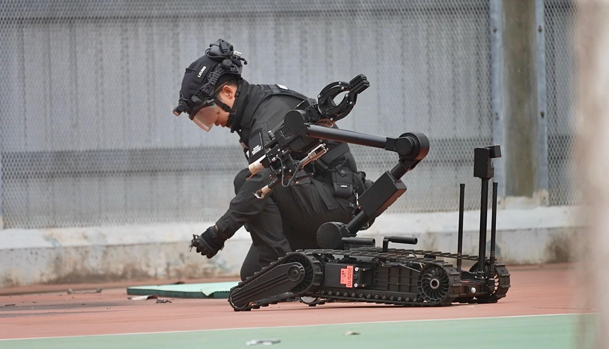 The Correctional Services Department (CSD) conducted a large-scale emergency exercise, code-named "Concord XXIV", at Hei Ling Chau Correctional Institution today (December 10). The exercise simulated a series of incidents, which included mass indiscipline by persons in custody (PICs), a hostage-taking situation, a PIC escape attempt, assaults on CSD staff, a fire and the discovery of explosives. Photo shows an officer of the Explosive Ordnance Disposal Bureau of the Hong Kong Police Force handling explosives.
