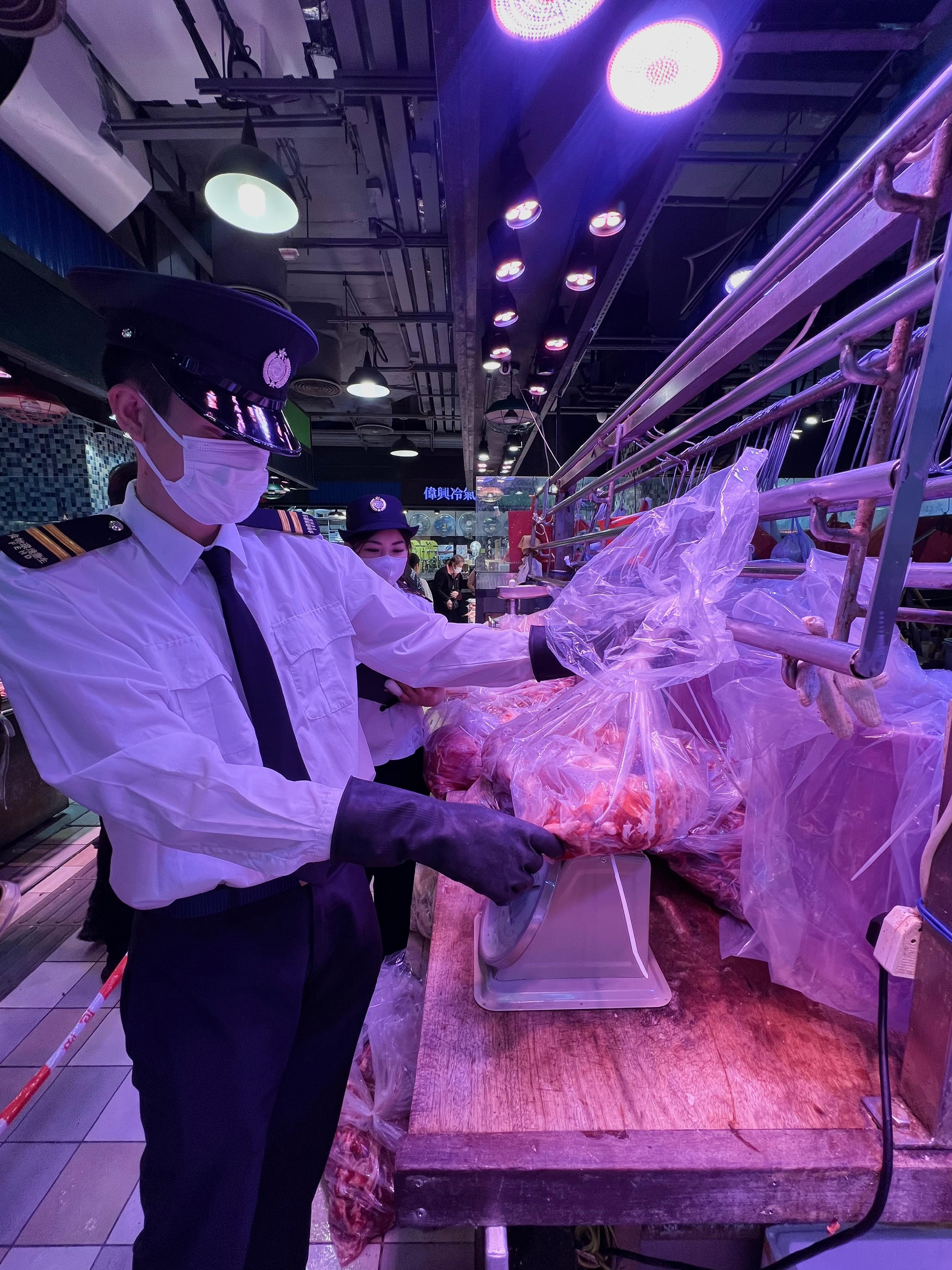 The Food and Environmental Hygiene Department (FEHD) today (December 10) conducted a raid on a licensed fresh provision shop in Sai Kung District suspected of selling frozen meat as fresh meat. Photo shows FEHD officers sealing some of the meat during the operation for further investigation.