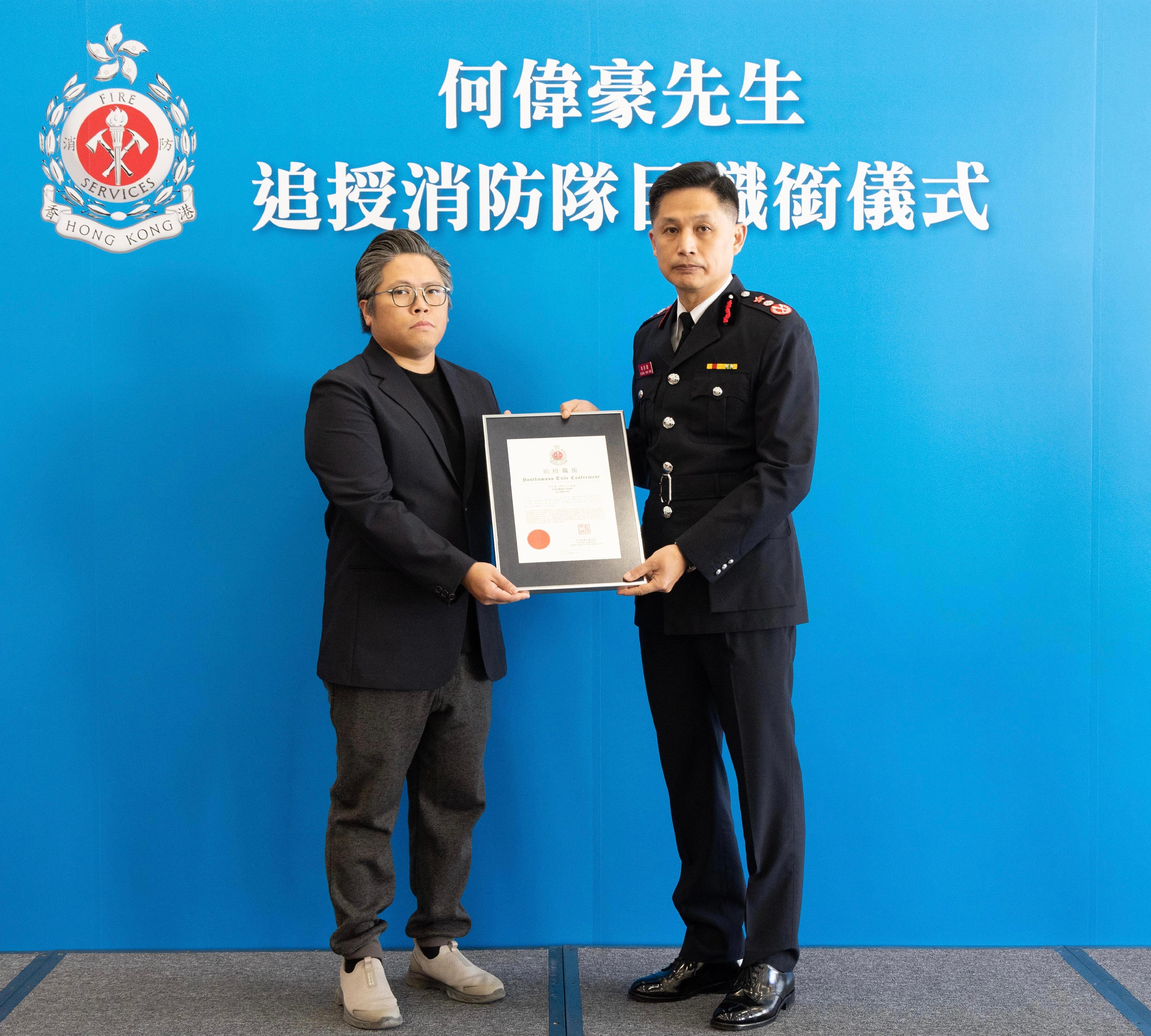 The Fire Services Department today (December 11) posthumously conferred the honorary title of Senior Fireman on the late Mr Ho Wai-ho in recognition of his exemplary service and selfless dedication to duty. Photo shows the Director of Fire Services, Mr Andy Yeung (right), presenting the posthumous title conferment certificate, which is accepted by a family member of Mr Ho.