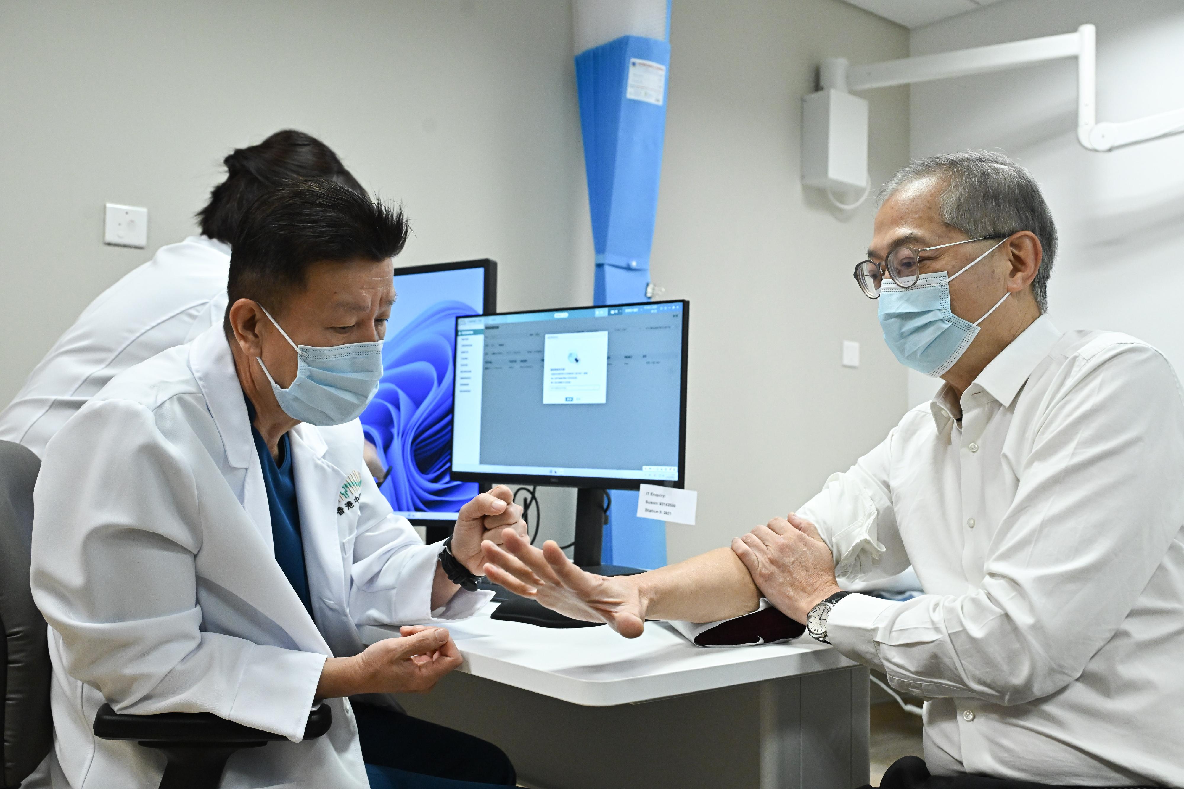 The Chinese Medicine Hospital of Hong Kong commenced operations in phases starting today (December 11). Photo shows the Secretary for Health, Professor Lo Chung-mau (right), experiencing a consultation session at the hospital today.