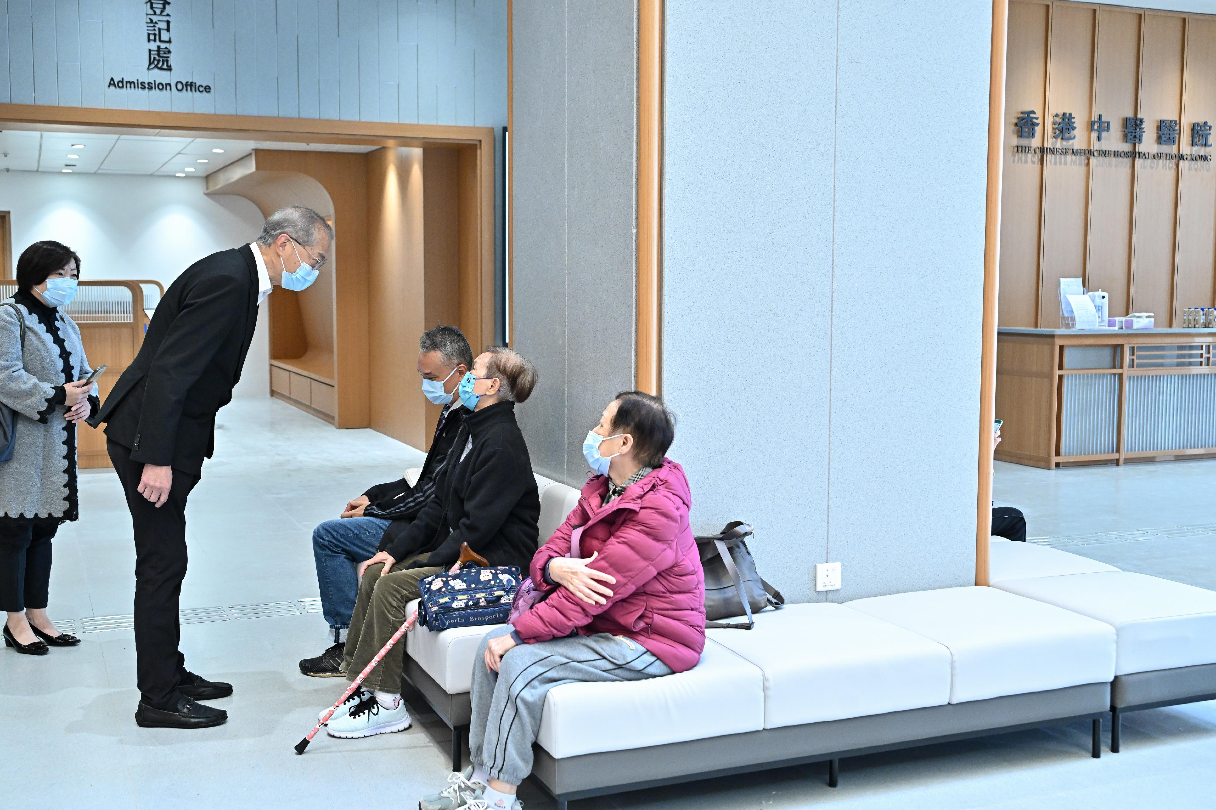 The Chinese Medicine Hospital of Hong Kong (CMHHK) commenced operations in phases starting today (December 11). Photo shows the Secretary for Health, Professor Lo Chung-mau (second left), chatting with citizens at the hospital's ground lobby to understand their opinions on the services of CMHHK.