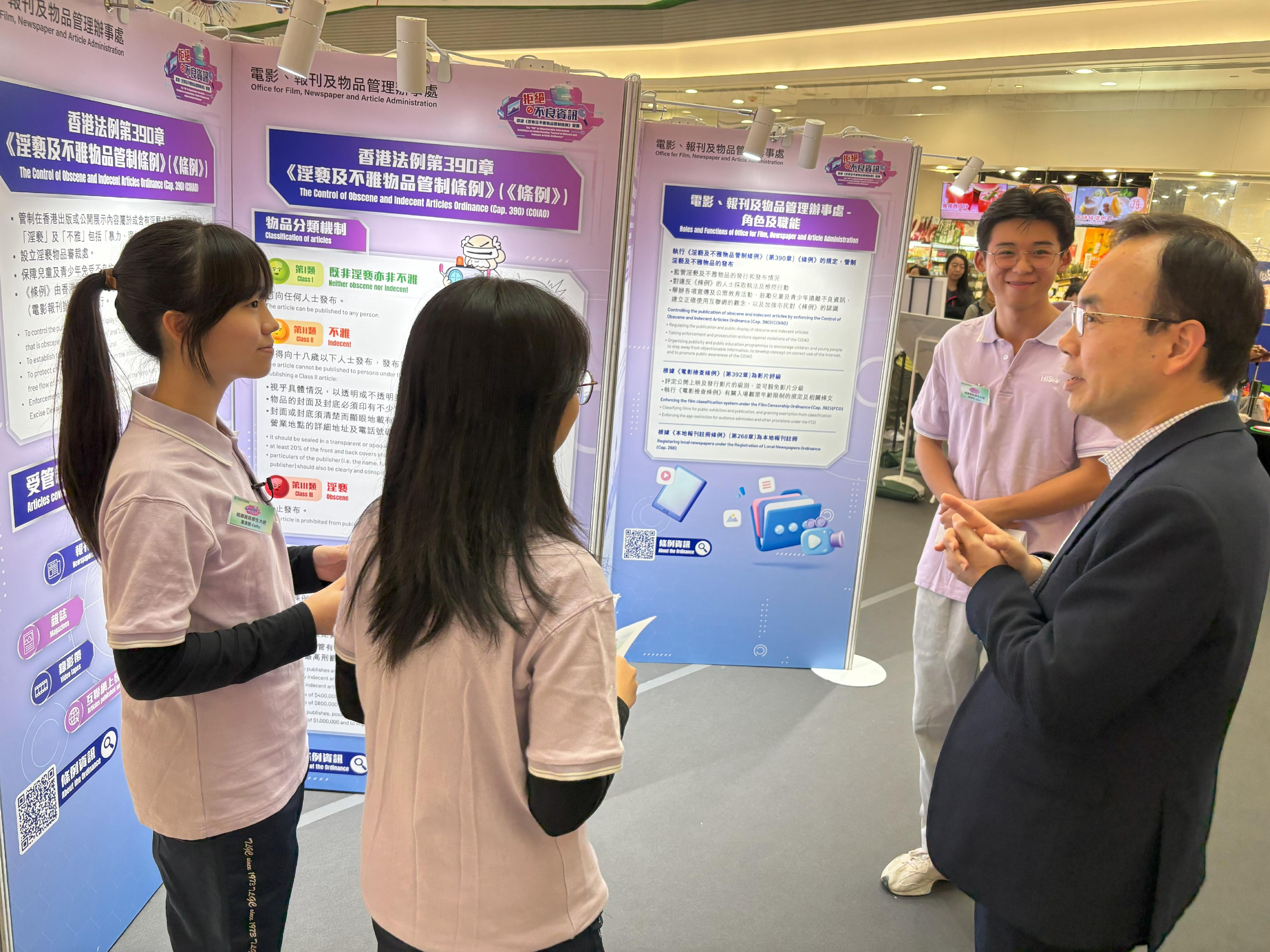 The Office for Film, Newspaper and Article Administration is holding a roving exhibition themed "Saying NO to Objectionable Information" at Domain Mall in Yau Tong for three consecutive days starting from today (December 12) to enhance the public's understanding of the Control of Obscene and Indecent Articles Ordinance and promote healthy Internet use. Photo shows the Director of Film, Newspaper and Article Administration, Mr Chaucer Leung (first right), interacting with the Healthy Information Student Ambassadors when visiting the exhibition.
