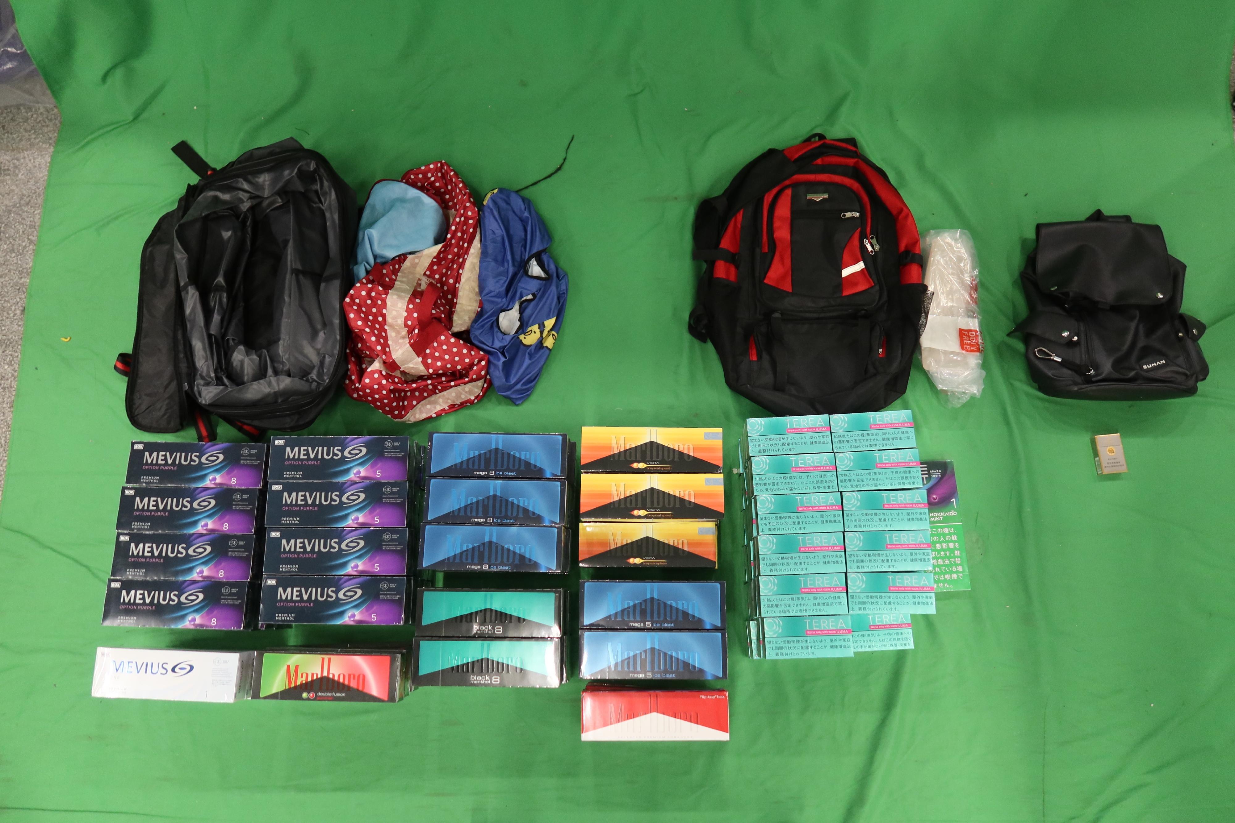 A 32-year-old incoming male passenger was sentenced to four months' imprisonment and fined $1,000 at the West Kowloon Magistrates' Courts today (December 12) for dealing with duty-not-paid cigarettes and failing to declare them to Customs officers, as well as for importing alternative smoking products, in contravention of the Dutiable Commodities Ordinance and the Import and Export Ordinance. Photo shows the duty-not-paid cigarettes and alternative smoking products seized.