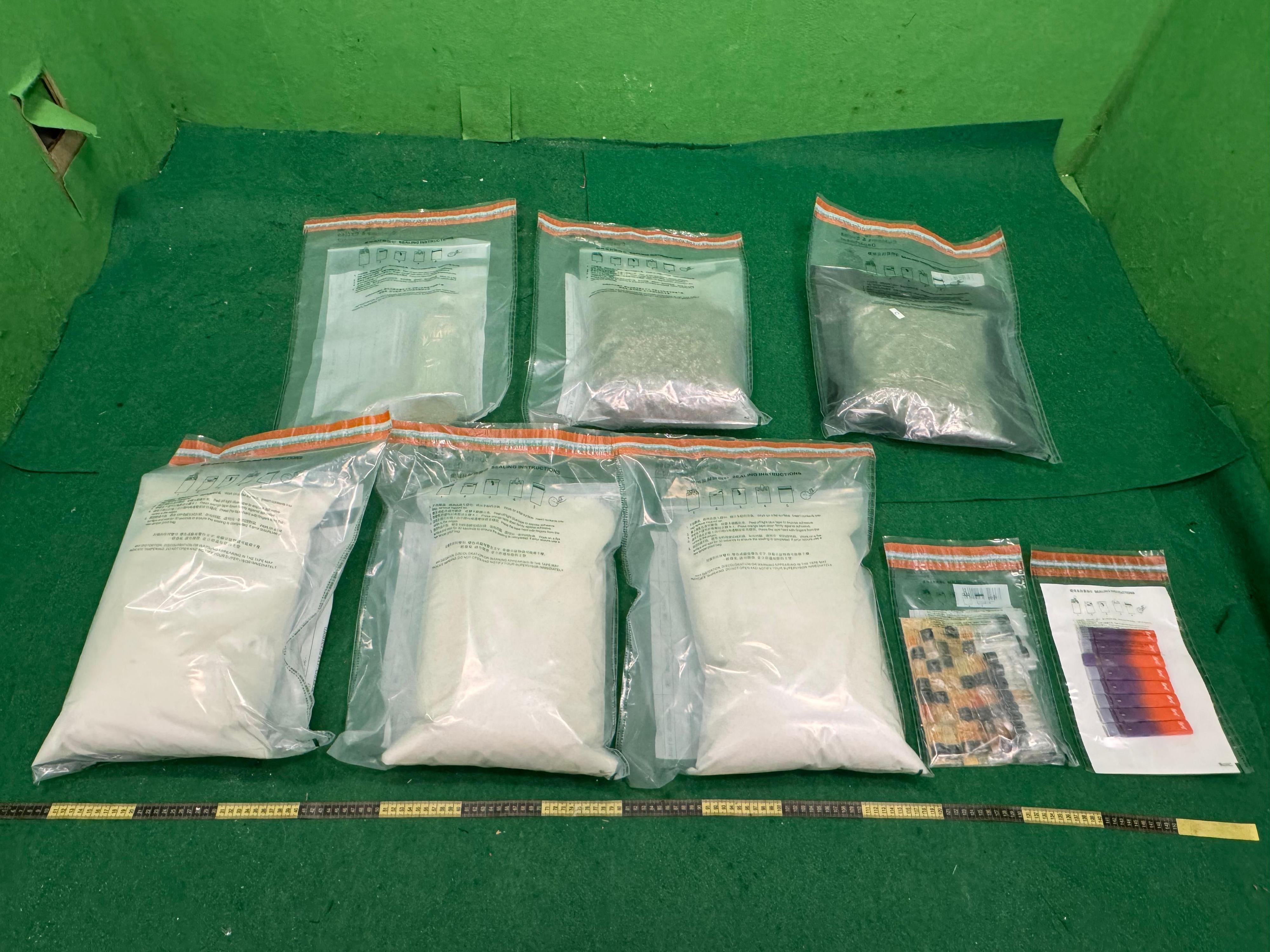 Hong Kong Customs detected a trafficking case involving air cargo and a drug trafficking case involving a passenger at Hong Kong International Airport, and shut down a suspected dangerous drugs distribution centre in Tai Po, seizing a total of about 15 kilograms of suspected ketamine, 1kg of suspected cannabis buds, 40 capsules of suspected etomidate, 660 grams of suspected liquid etomidate, 8g of suspected cannabis oil and 1.7kg of suspected heroin, with a total estimated market value of about $8.9 million. Three males were arrested. Photo shows the suspected dangerous drugs seized in the first case.
