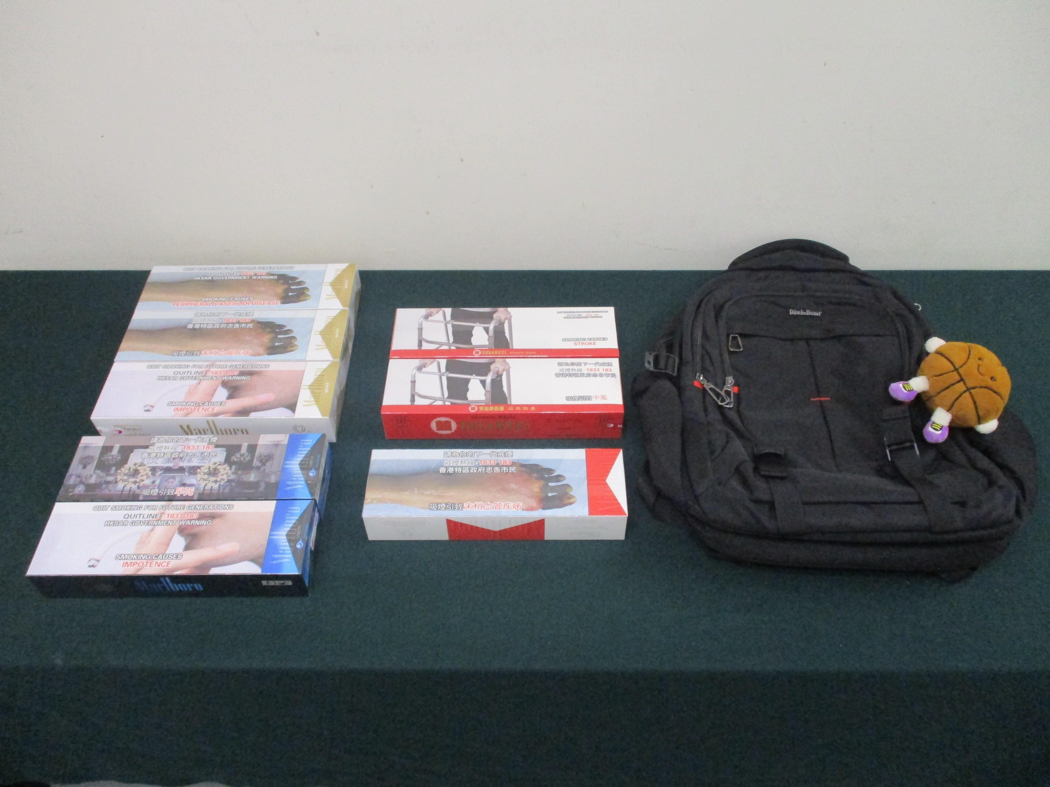 一名四十八歲抵港女旅客因管有未完稅香煙和未有向海關人員作出申報,違反《應課稅品條例》,今日(十二月十二日)在粉嶺裁判法院被判處監禁四星期及罰款八百元。圖示檢獲的未完稅香煙和用作收藏未完稅香煙的背包。