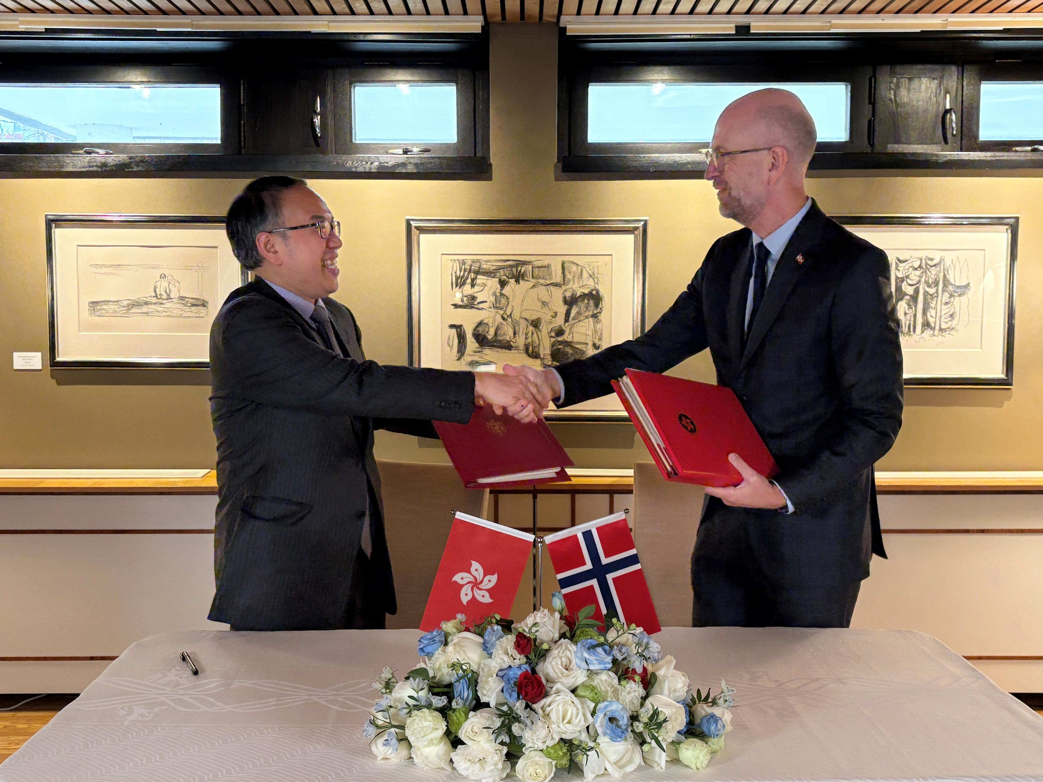 The Secretary for Financial Services and the Treasury, Mr Christopher Hui (left), exchanges documents with the Ambassador of Norway to China, Mr Vebj&oslash;rn Dysvik (right), after signing a comprehensive avoidance of double taxation agreement in Beijing today (December 16).