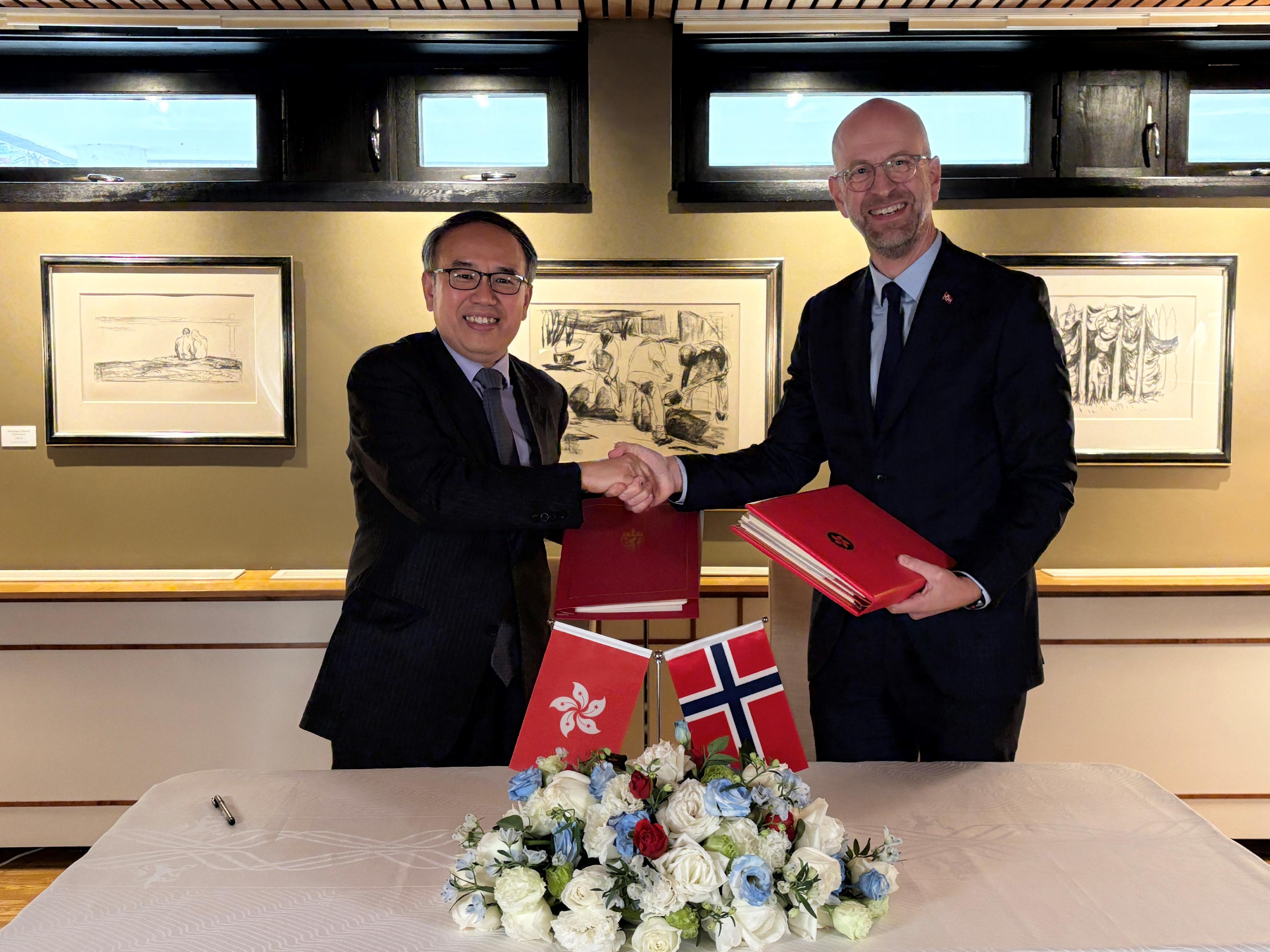 The Secretary for Financial Services and the Treasury, Mr Christopher Hui (left), exchanges documents with the Ambassador of Norway to China, Mr Vebj&oslash;rn Dysvik (right), after signing a comprehensive avoidance of double taxation agreement in Beijing today (December 16).