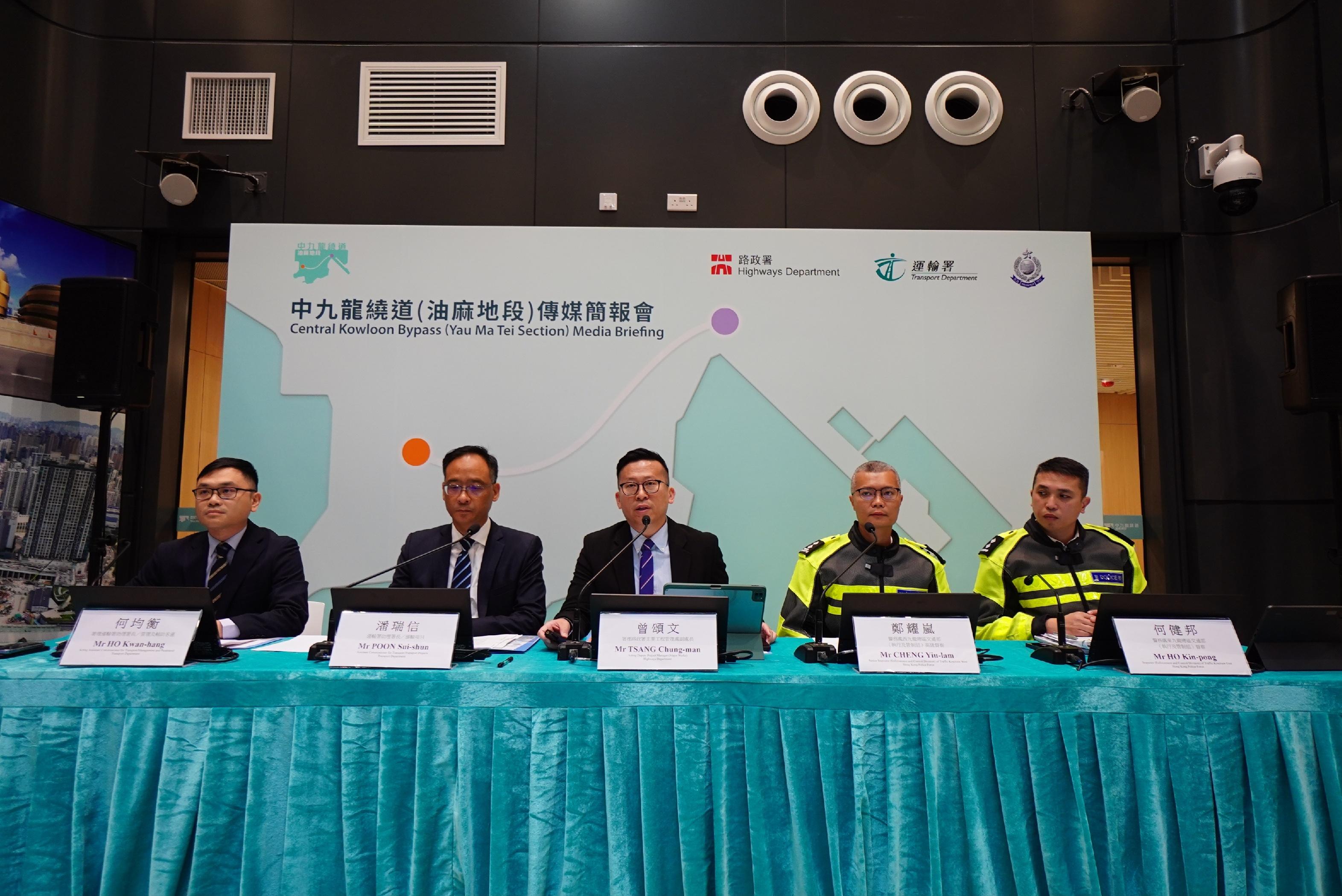 路政署今日(十二月十六日)聯同運輸署及警務處於中九龍繞道(油麻地段)行政大樓舉行傳媒簡報會,交代中九龍繞道(油麻地段)於十二月二十一日(星期日)通車的具體安排。圖示署理路政署主要工程管理處副處長曾頌文(中)、運輸署助理署長/運輸項目潘瑞信(左二)和署理助理署長/管理及輔助客運何均衡(左一),以及警務處西九龍總區交通部(執行及管制組)高級督察鄭耀嵐(右二)和東九龍總區交通部(執行及管制組)督察何健邦(右一)出席簡報會。