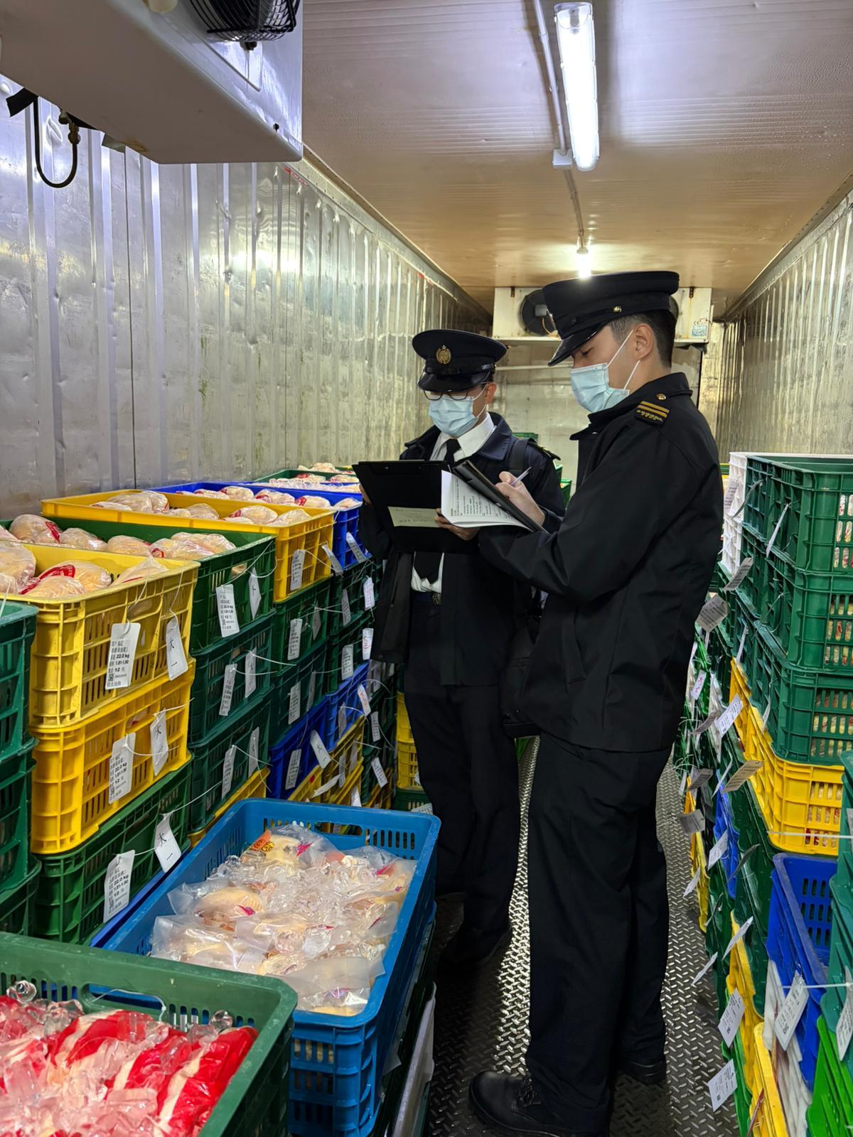 The Food and Environmental Hygiene Department (FEHD) raided an unlicensed cold store last night (December 17) in Pat Heung, Yuen Long. Photo shows FEHD officers checking the store's stock.