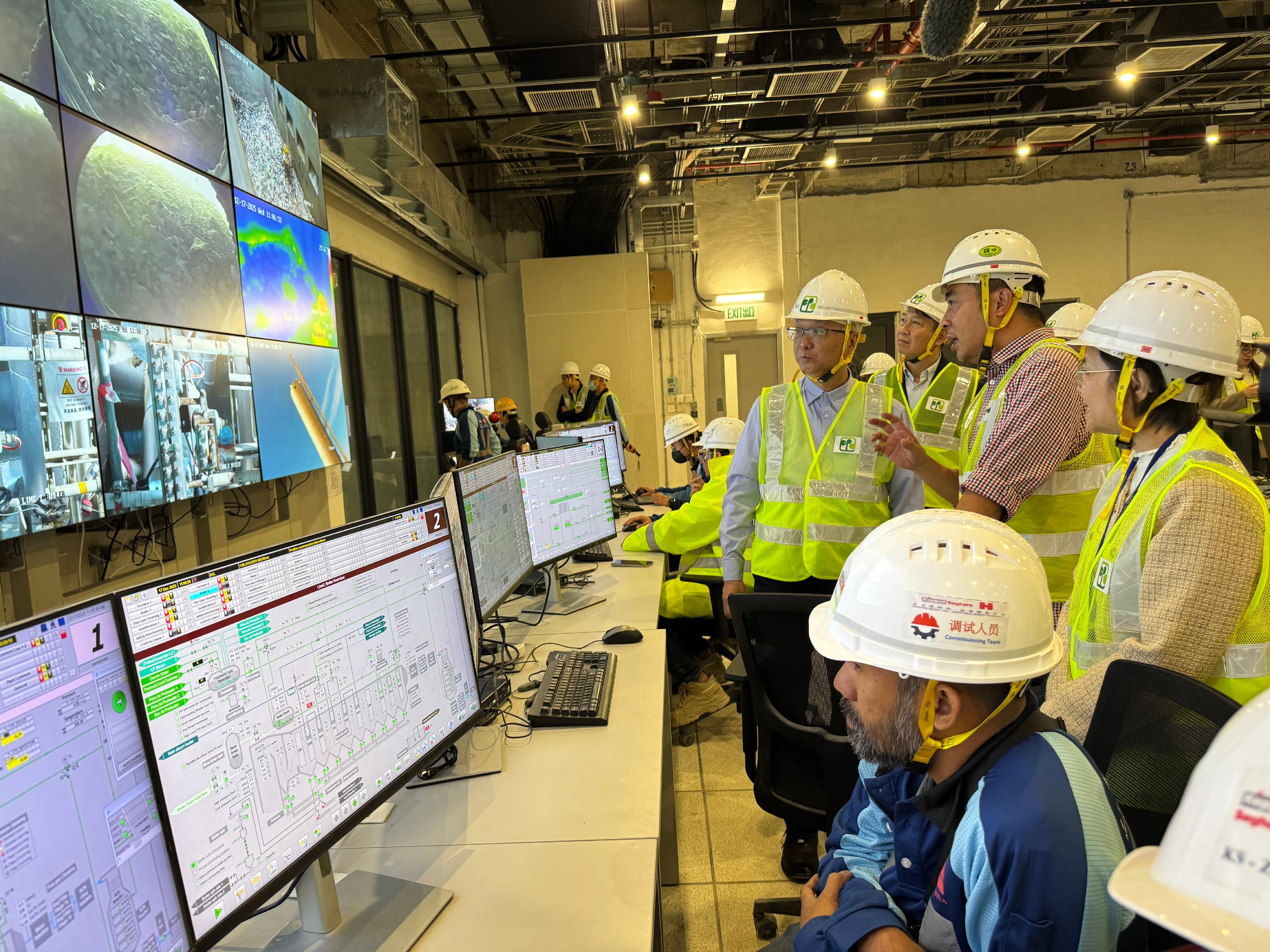 The Environmental Protection Department announced that the Integrated Waste Management Facilities Phase I has commenced the first phase of trial operation. Photo shows the Secretary for Environment and Ecology, Mr Tse Chin-wan (back row, fourth right); the Permanent Secretary for Environment and Ecology (Environment), Mr Eddie Cheung (back row, third right); and the Under Secretary for Environment and Ecology, Miss Diane Wong (back row, first right), recently inspecting its operations and observing the waste treatment processes in the central control room.