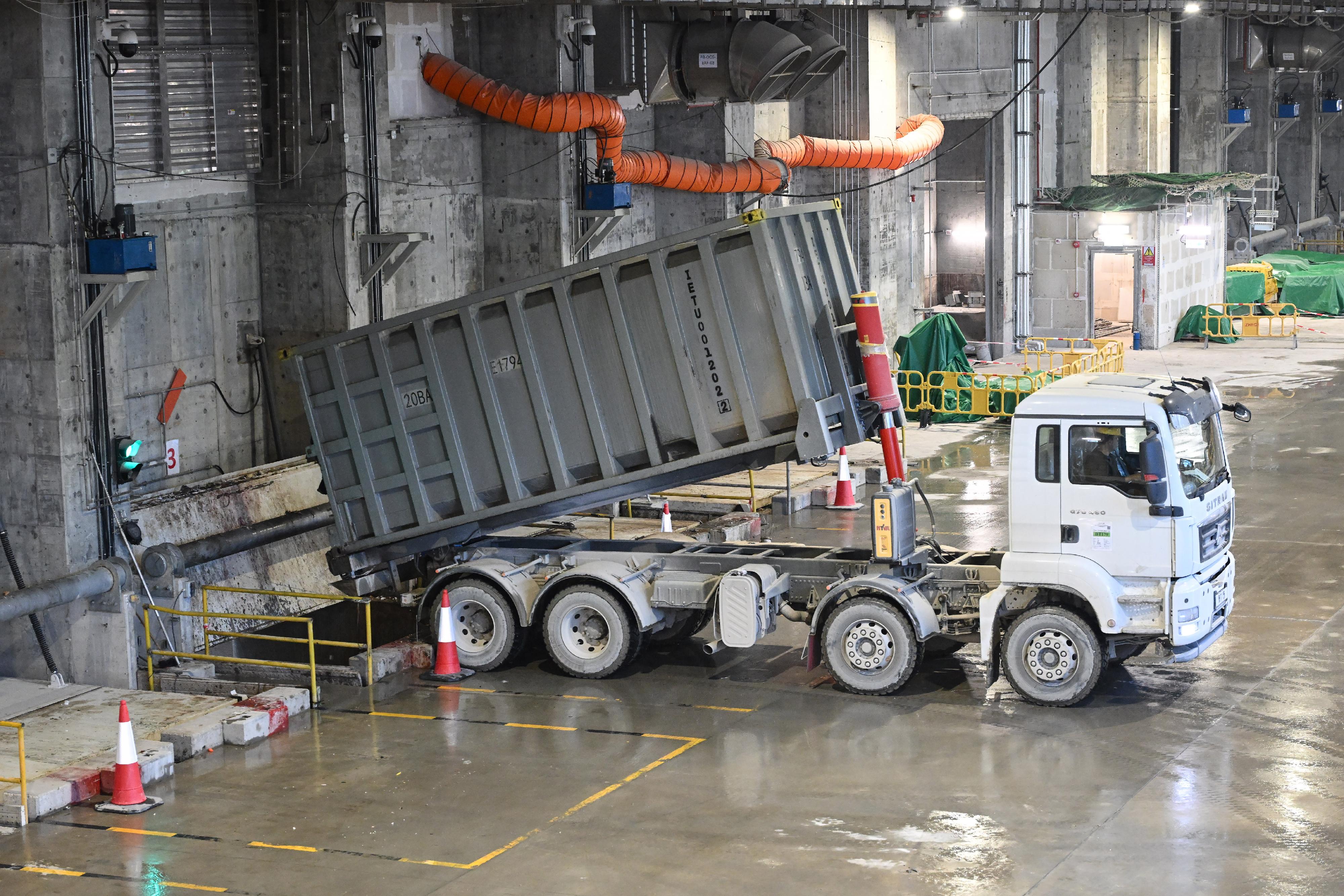 The Environmental Protection Department announced that the Integrated Waste Management Facilities Phase I has commenced the first phase of trial operation. Photo shows a truck unloading municipal solid waste to a bunker in the tipping hall.
