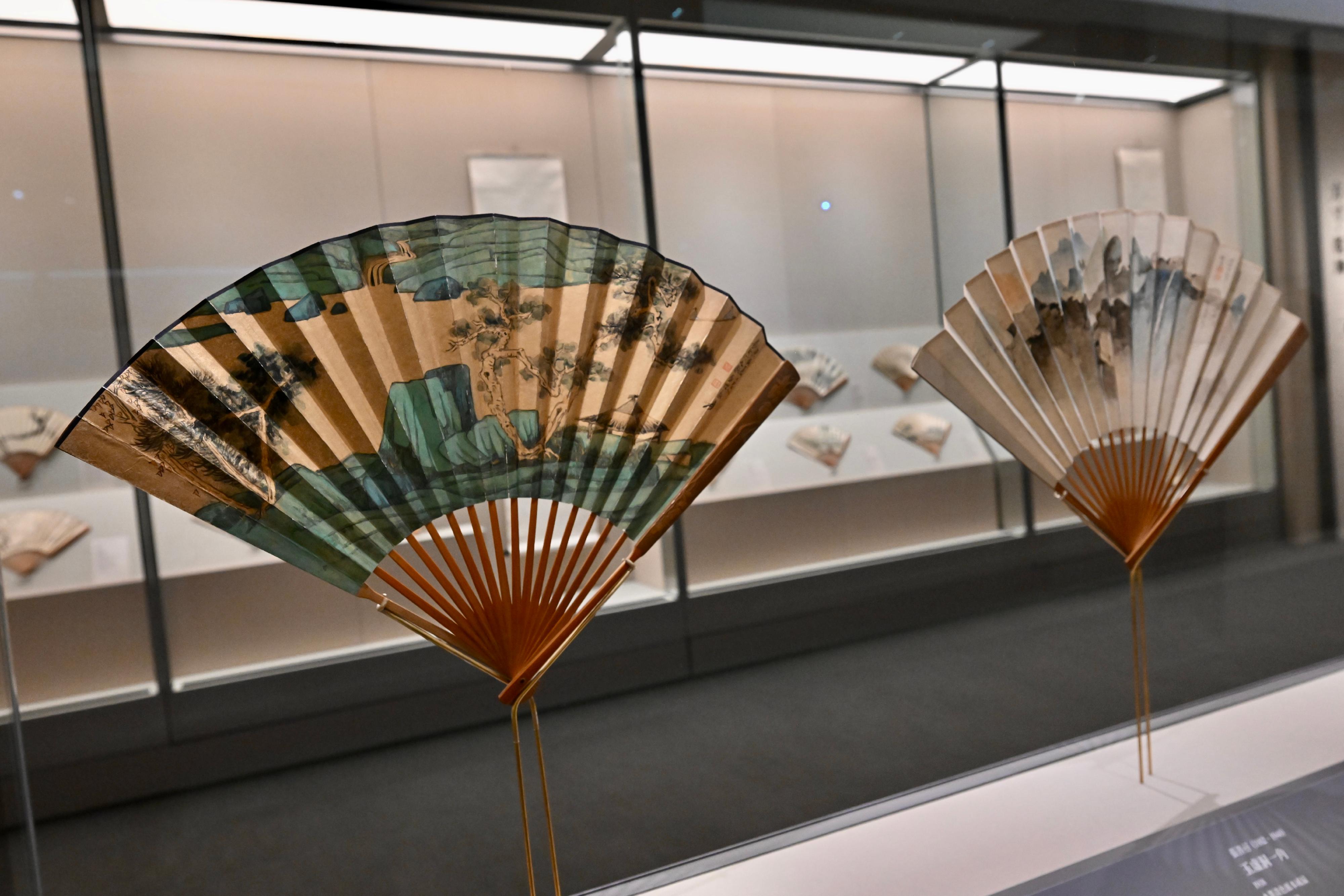 The Hong Kong Museum of Art (HKMoA) today (December 23) unveils the "Fantastic Breeze: Selected Fans from the Jingguanlou Collection" exhibition. Through thoughtfully designed display methods, the exhibition highlights the dual-sided aesthetics of folding fans. Photo shows Zhang Daqian's "Thatched Pavilion at the Riverbank" (left) and Zhang Shanzi's "Scene of Yuxu Cave" (right). 
