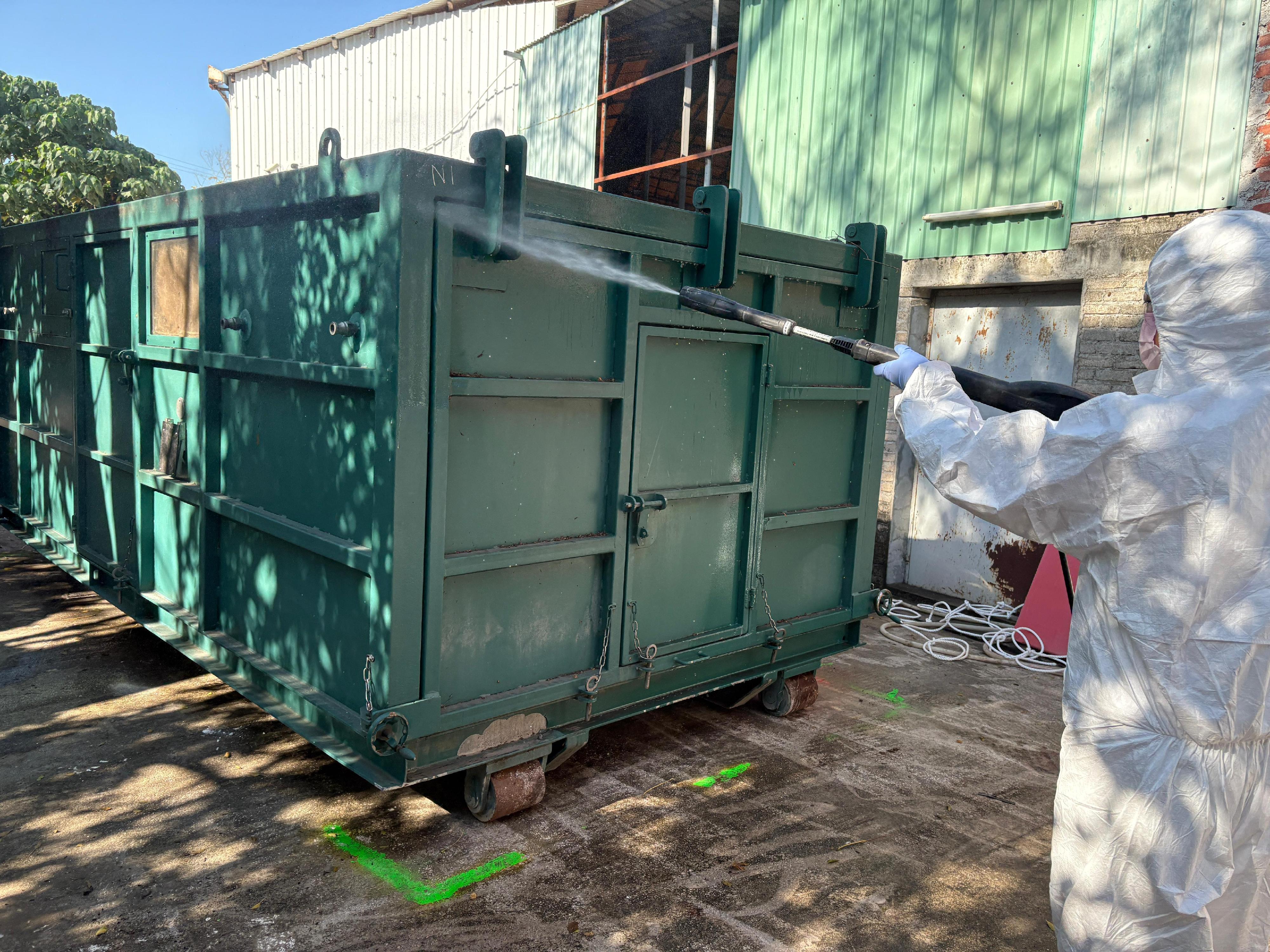 就渔农自然护理署（渔护署）十二月十七日公布，在元朗流浮山一持牌猪场的猪只样本检测出非洲猪瘟病毒的事件。渔护署根据非洲猪瘟应变方案，十二月十九日起展开行动，派员到涉事的持牌猪场销毁及处理所有场内猪只。图示渔护署人员为二氧化碳气室进行消毒。