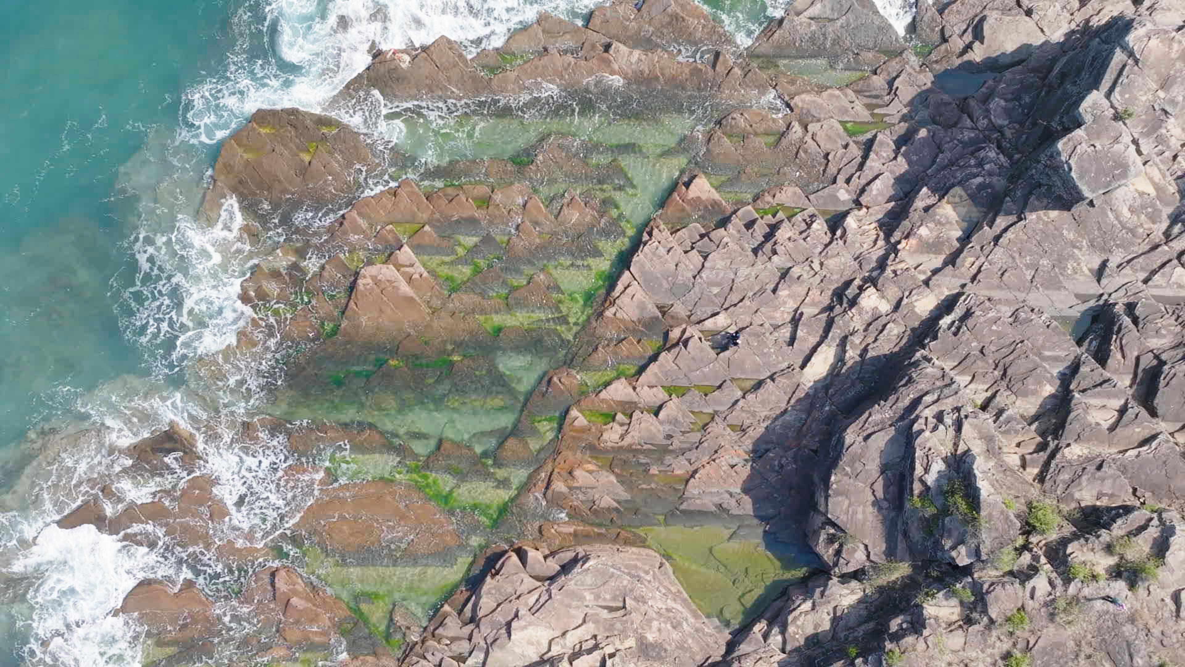 国家生态环境部公布第四批全国「美丽海湾」评选结果，香港大鹏湾以优异的综合评分成功获选为「美丽海湾优秀案例」。图示位于香港大鹏湾内的东平洲海岸公园水质清澈见底，薄层状粉砂岩地貌极具特色，深受游人喜爱。从空中俯瞰其海蚀平台，景色如画，气势磅礴。