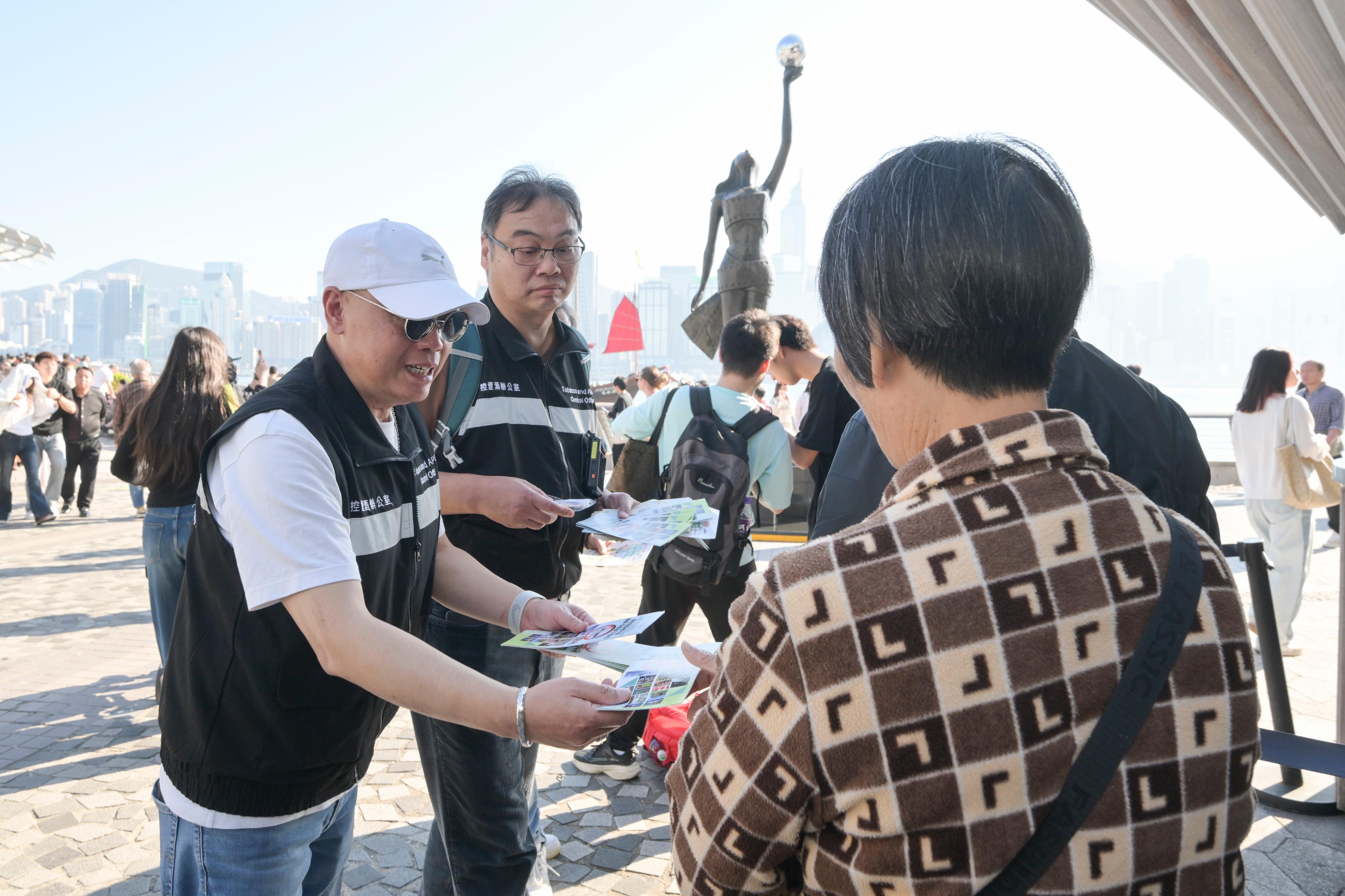 衞生署今日（十二月二十九日）提醒市民新一階段控煙措施將於二○二六年一月一日生效。圖示控煙酒辦人員於尖沙咀向旅客派發有關控煙措施的宣傳單張。