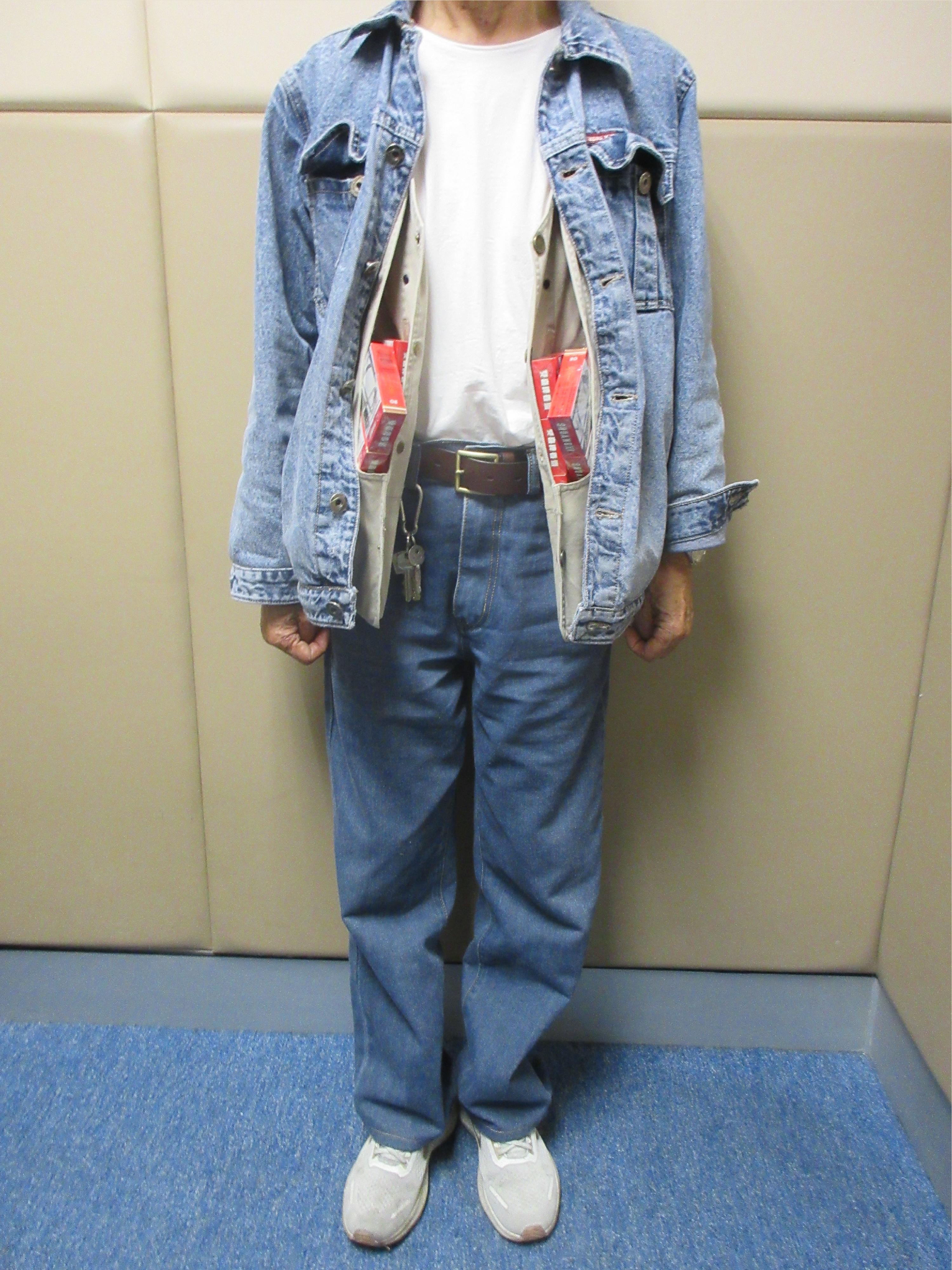 An 83-year-old incoming male passenger was sentenced to eight weeks' imprisonment by the Fanling Magistrates' Courts today (December 29) for possessing duty-not-paid cigarettes and failing to declare them to Customs officers, in contravention of the Dutiable Commodities Ordinance. Photo shows the man using the inner pockets of a vest worn by him to conceal the duty-not-paid cigarettes.