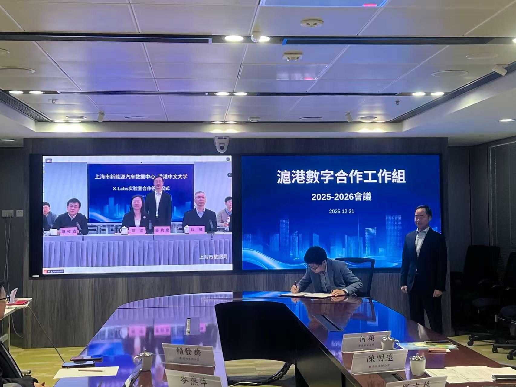 The second meeting of the Working Group on Shanghai and Hong Kong Digital Co-operation was held via video conferencing today (December 31). Photo shows the Commissioner for Digital Policy, Mr Tony Wong (right), and the Director of the Shanghai Municipal Bureau of Data, Dr Shao Jun (third right, left screen), jointly witnessing the signing of co-operation agreement between Shanghai Electric Vehicle Public Data Collecting, Monitoring and Research Center and the Chinese University of Hong Kong regarding the Shanghai Electric Vehicle (Jaiding) Data Innovation Laboratory via viedo conferencing.