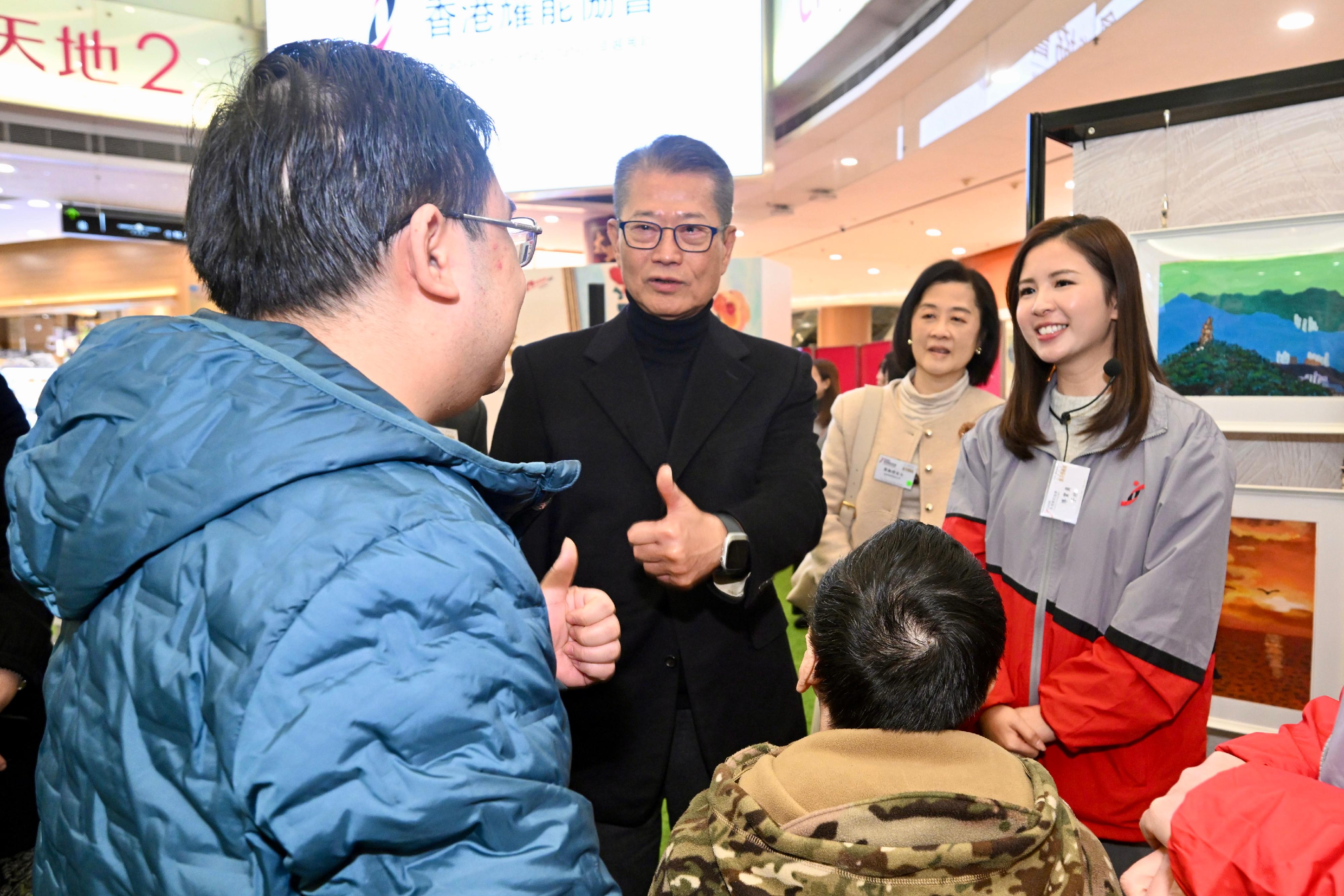 財政司司長陳茂波今日(一月八日)出席香港耀能協會慈善藝術展啓動禮。圖示陳茂波(左二)與其他嘉賓參觀展覽。