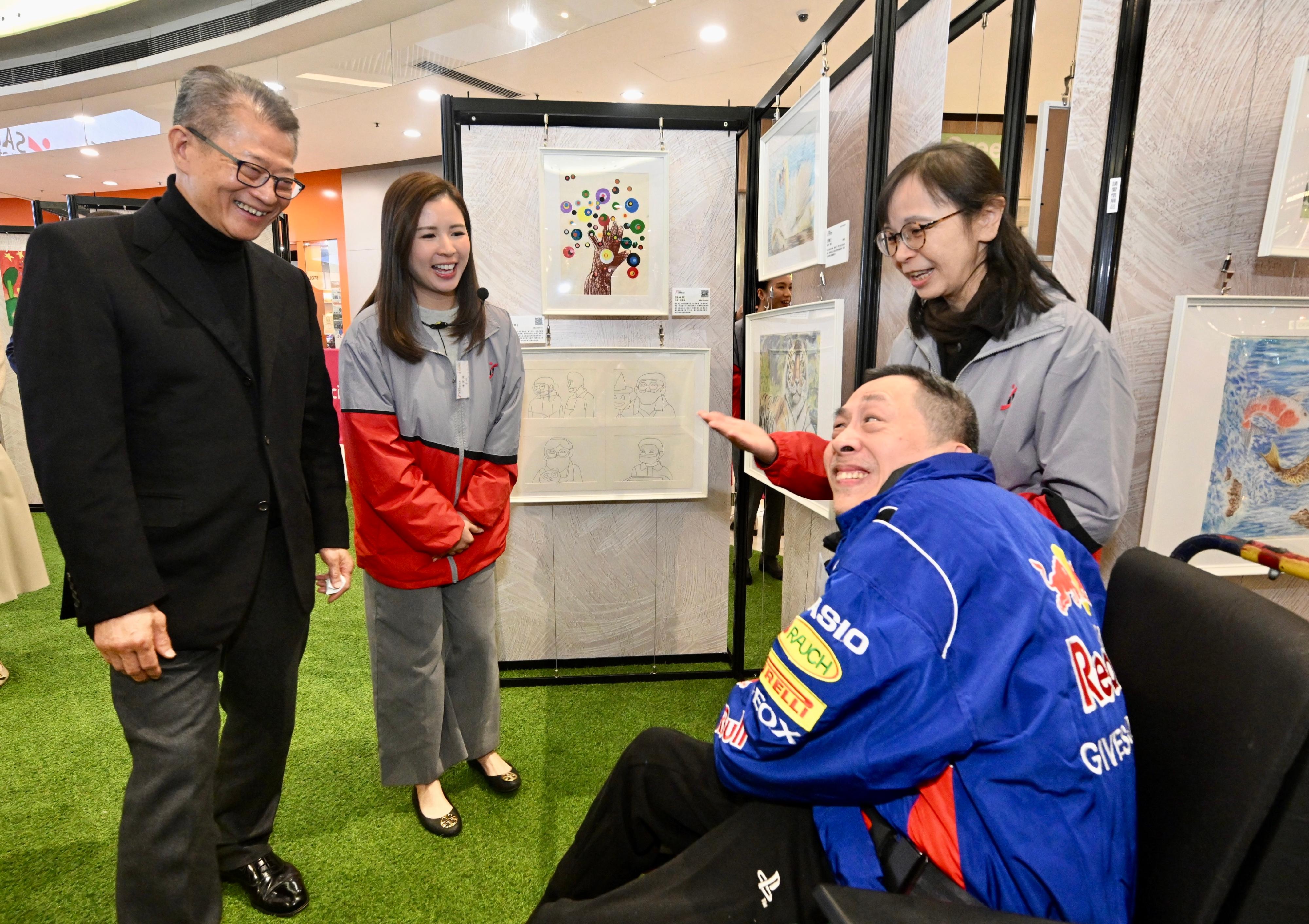 財政司司長陳茂波今日(一月八日)出席香港耀能協會慈善藝術展啓動禮。圖示陳茂波(左一)參觀展覽。