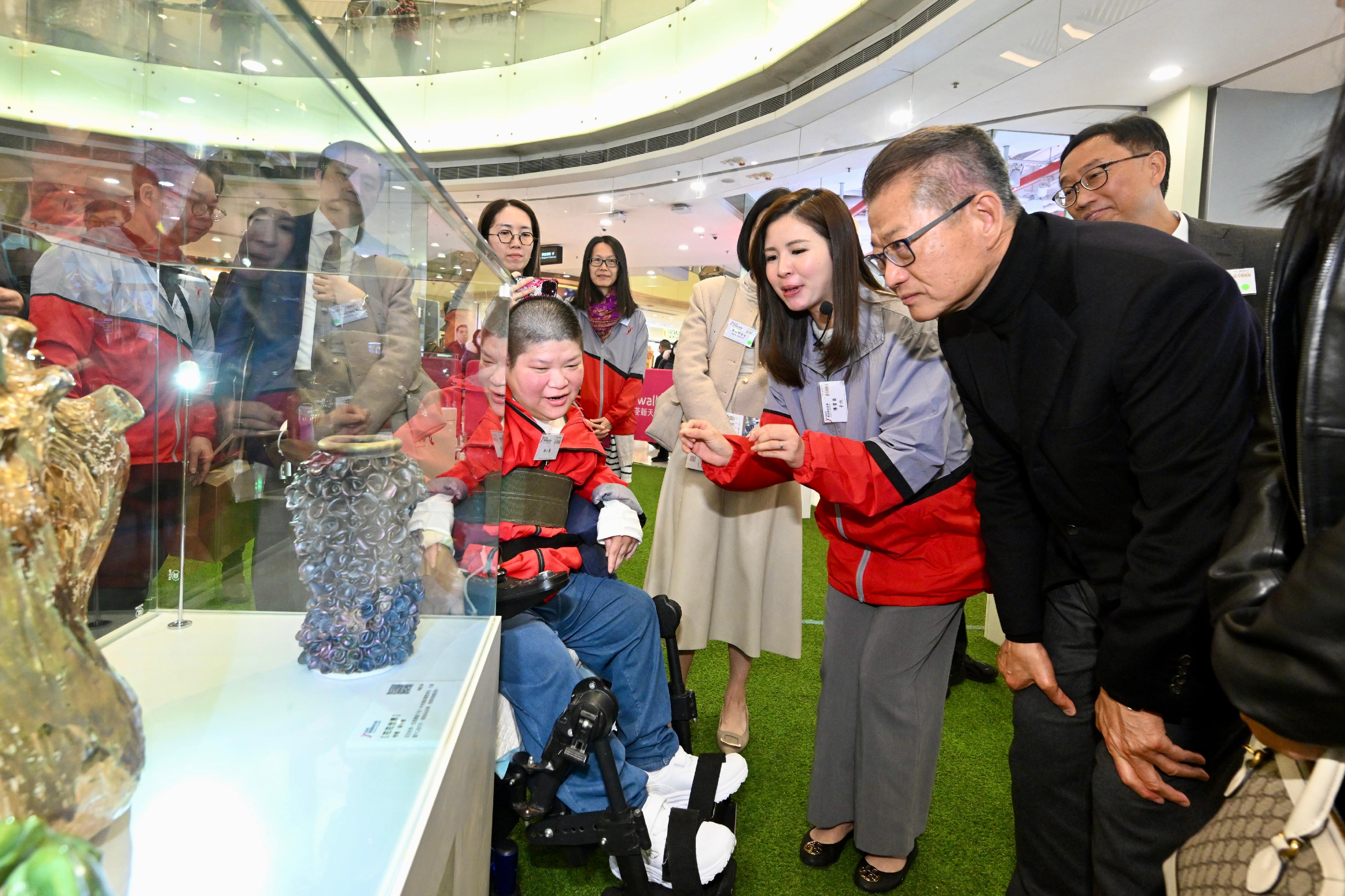 財政司司長陳茂波今日(一月八日)出席香港耀能協會慈善藝術展啓動禮。圖示陳茂波(右二)與其他嘉賓參觀展覽。