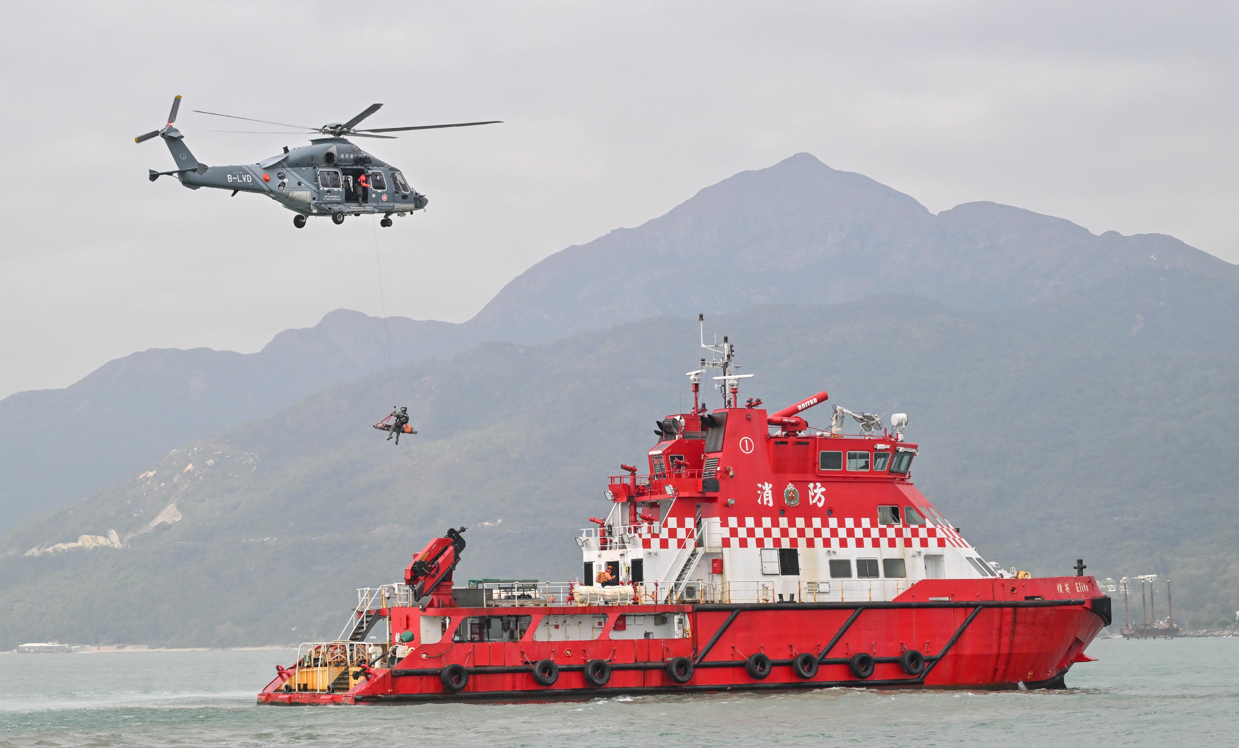The Civil Aviation Department (CAD) held a joint short-range Aeronautical Search and Rescue exercise today (January 12) in the waters near Mong Tung Wan on the Chi Ma Wan Peninsula, Lantau Island. The exercise involved eight government departments and one search and rescue unit, namely CAD, the Government Flying Service (GFS), the Hong Kong Police Force, the Fire Services Department (FSD), the Marine Department, the Civil Aid Service, the Auxiliary Medical Service and the Hong Kong Observatory, and the Hong Kong Garrison of the Chinese People's Liberation Army respectively. Photo shows a simulation of a survivor being airlifted by a GFS helicopter upon being rescued by FSD officers.