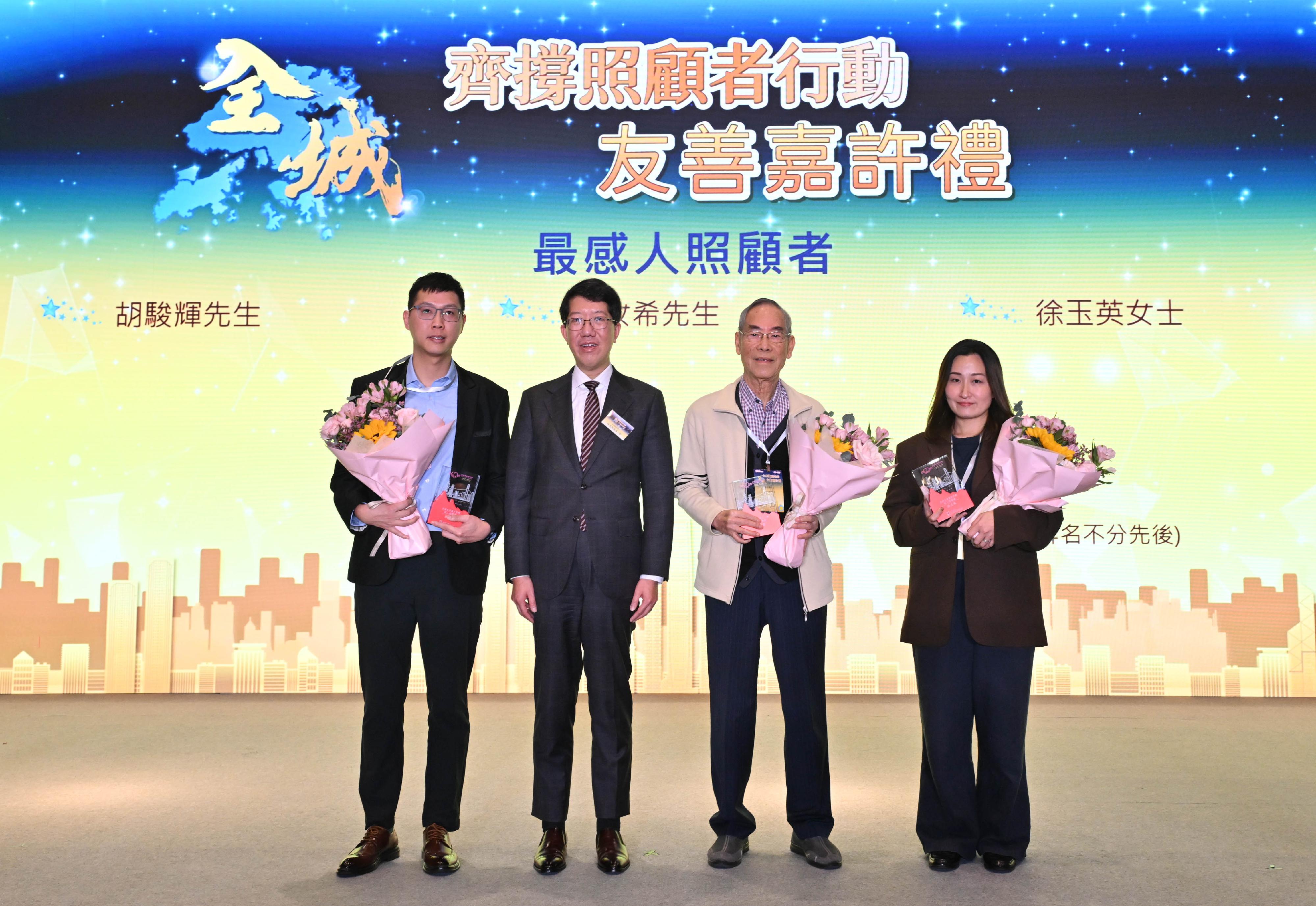 社會福利署（社署）今日（一月十三日）舉辦「齊撐照顧者行動&mdash;全城友善嘉許禮」，表揚照顧者及積極支援照顧者的鄰舍和僱主，並呼籲社會各界繼續支持和關懷照顧者。圖示社署署長杜永恒（左二）與獲嘉許的最感人照顧者合照。