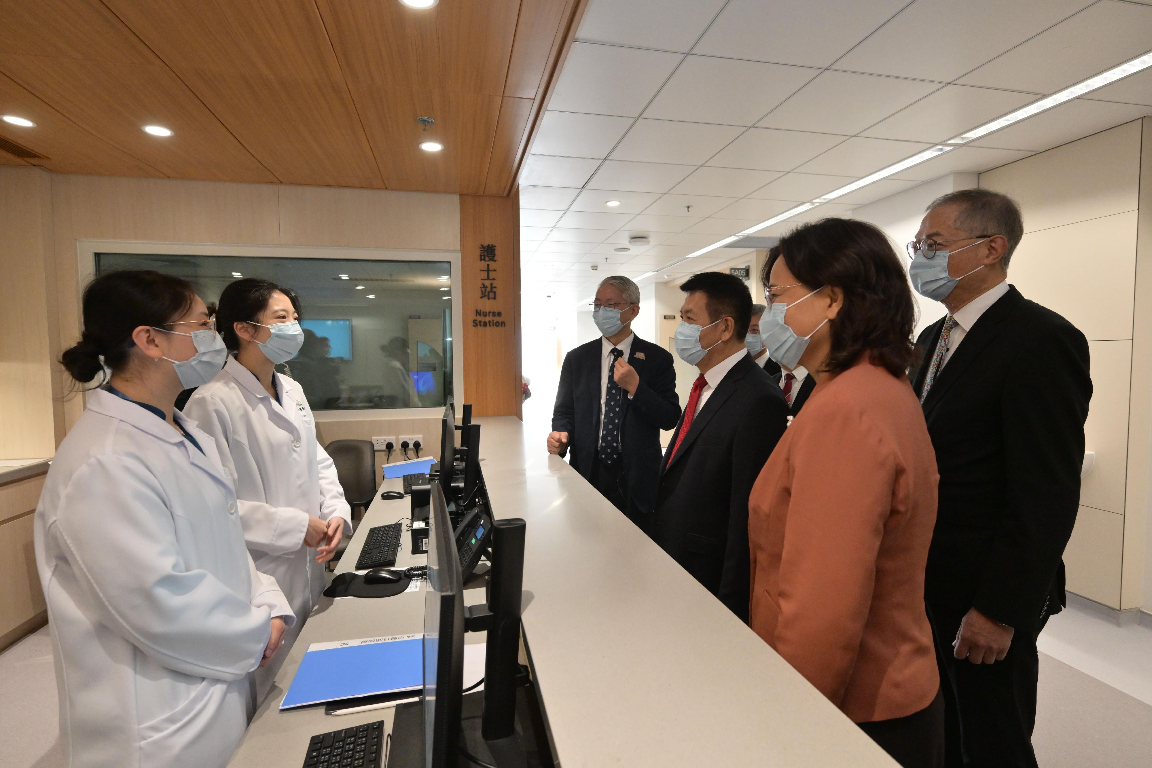 The Minister of the National Health Commission, Mr Lei Haichao (third right); the Commissioner of the National Administration of Traditional Chinese Medicine, Ms Yu Yanhong (second right); and the Secretary for Health, Professor Lo Chung-mau (first right), visit The Chinese Medicine Hospital of Hong Kong (CMHHK) and chat with nurses of the hospital in the company of the Hospital Chief Executive of CMHHK, Professor Bian Zhaoxiang (fourth right), today (January 13).
