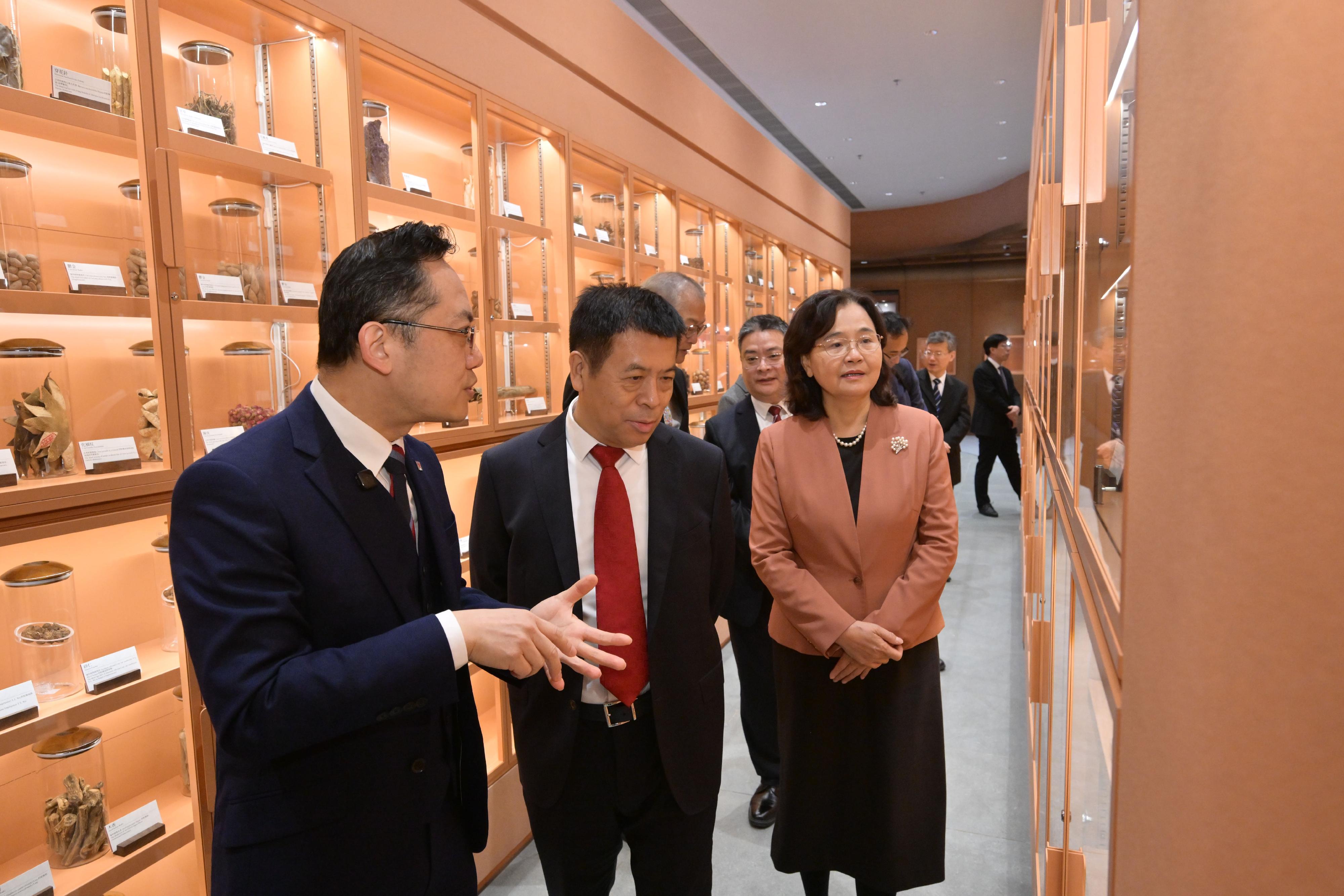 The Minister of the National Health Commission, Mr Lei Haichao (centre), and the Commissioner of the National Administration of Traditional Chinese Medicine, Ms Yu Yanhong (right), receive a briefing from the Director of Health, Dr Ronald Lam (left), on the Chinese medicines specimens of the Government Chinese Medicines Testing Institute today (January 13).

