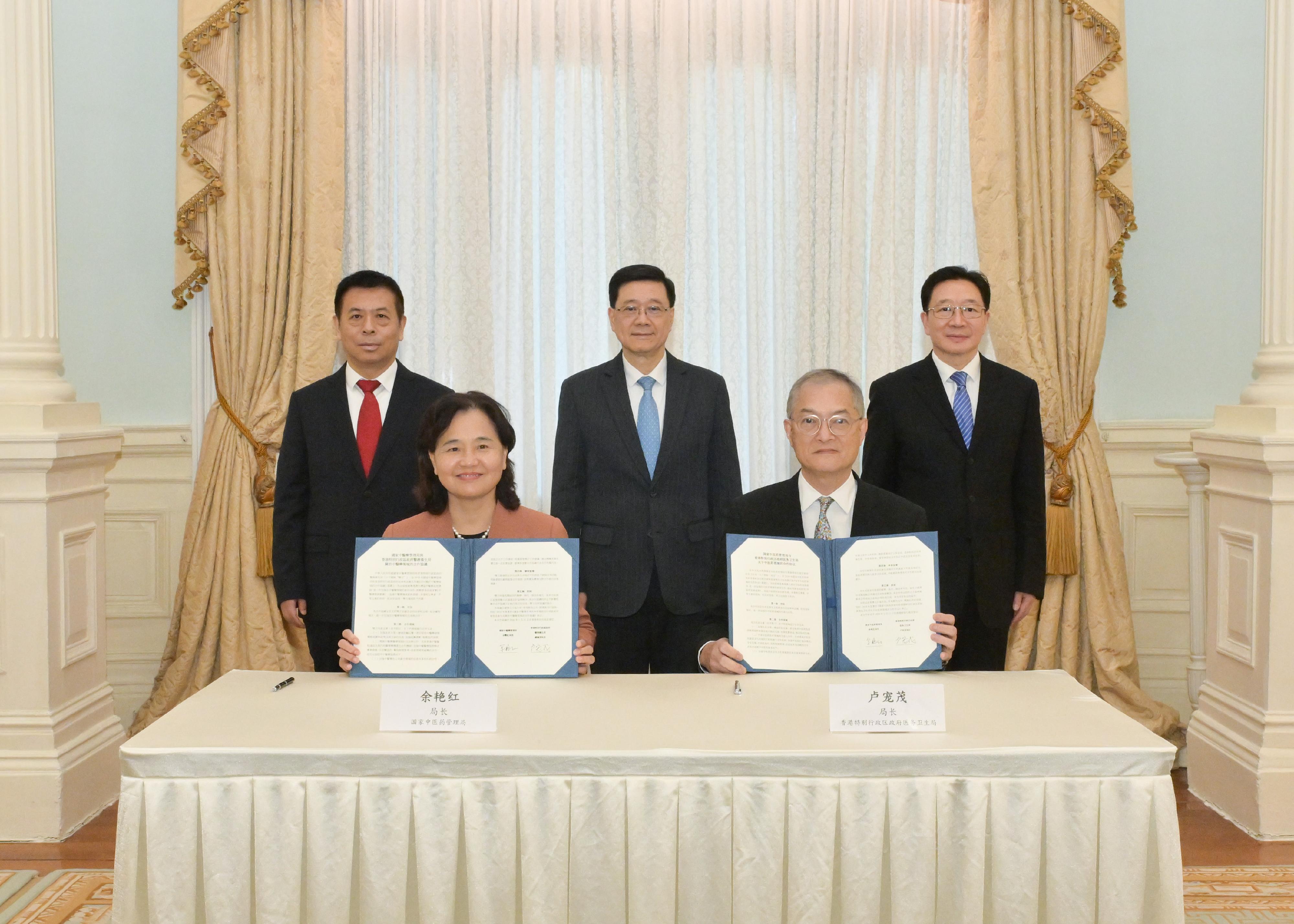 The Chief Executive, Mr John Lee (back row, centre); the Minister of the National Health Commission, Mr Lei Haichao (back row, left); and the Director of the Liaison Office of the Central People's Government in the Hong Kong Special Administrative Region, Mr Zhou Ji (back row, right), witness the signing of the co-operation agreement on Chinese medicine by the Commissioner of the National Administration of Traditional Chinese Medicine, Ms Yu Yanhong (front row, left), and the Secretary for Health, Professor Lo Chung-mau (front row, right), today (January 13).