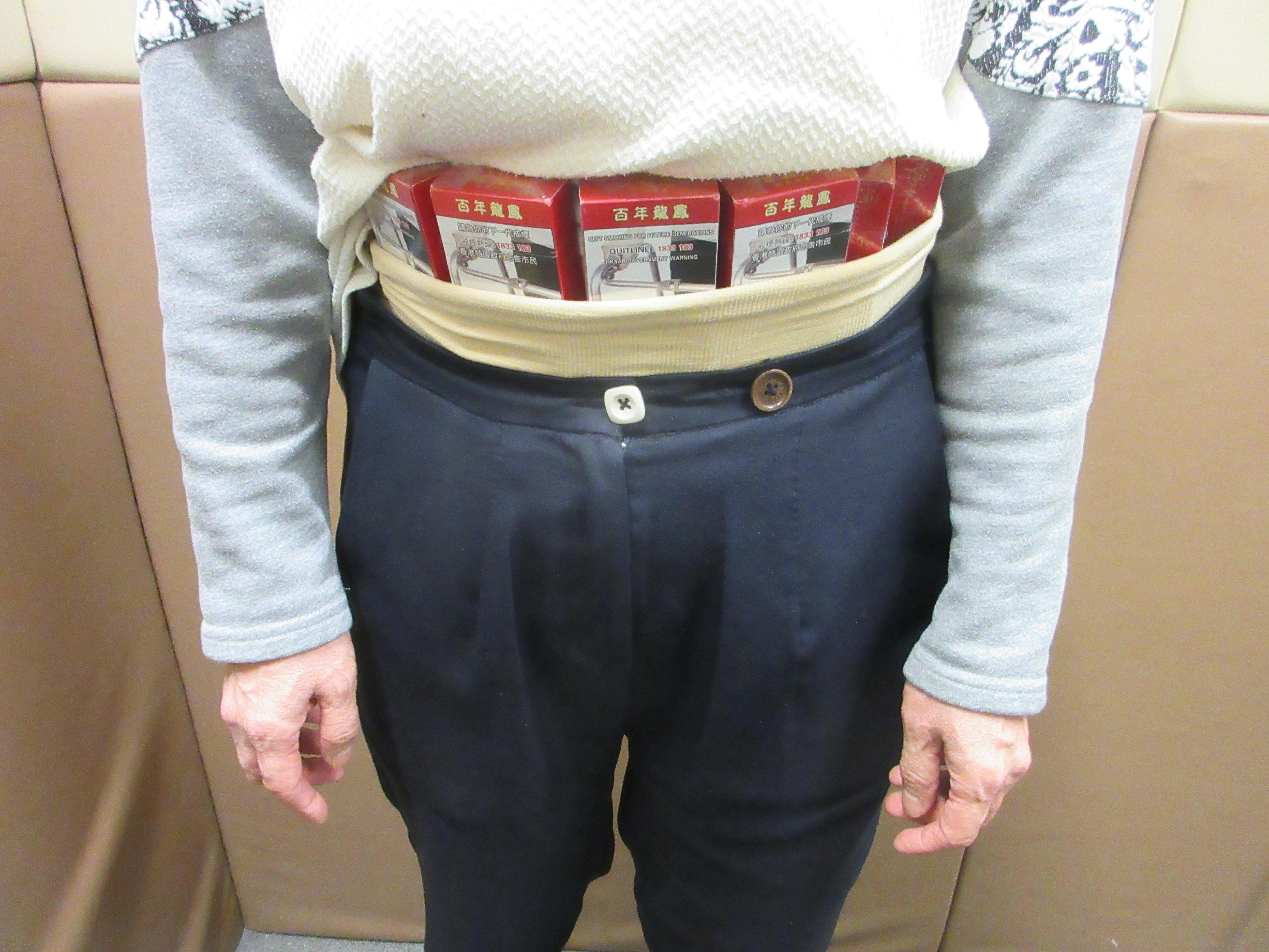 A 67-year-old incoming female passenger was sentenced to two months' imprisonment and fined $2,000 by the Fanling Magistrates' Courts today (January 14) for possessing duty-not-paid cigarettes and failing to declare them to Customs officers, in contravention of the Dutiable Commodities Ordinance. Photo shows the woman concealing the duty-not-paid cigarettes around her waist area.