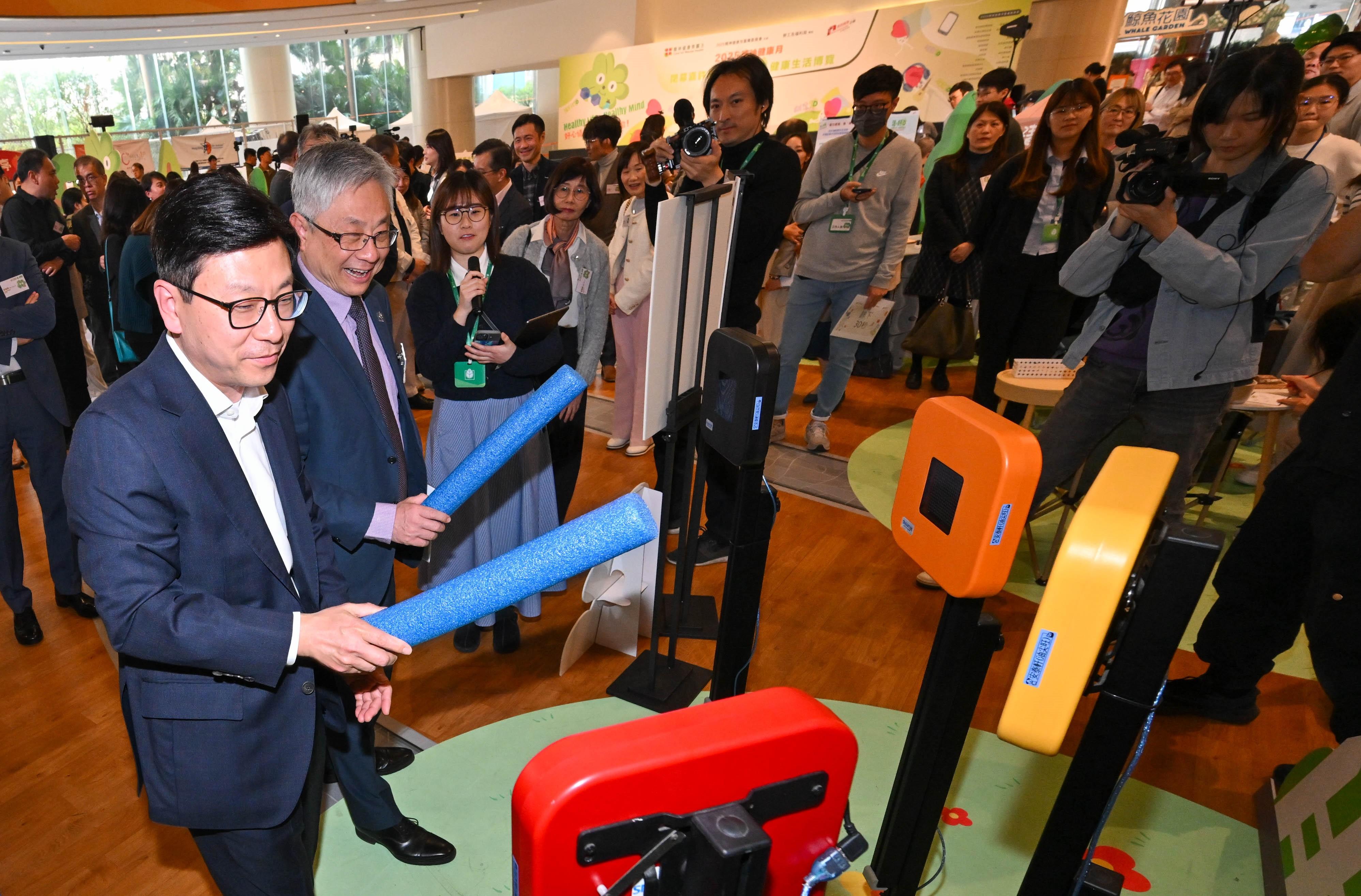 勞工及福利局局長孫玉菡今日(一月十七日)為「2025精神健康月」閉幕嘉許禮暨「活。好D」健康生活博覽主禮。圖示孫玉菡(左一)和「2025精神健康月」籌備委員會主席朱世明(左二)參與推廣恆常運動的攤位遊戲。