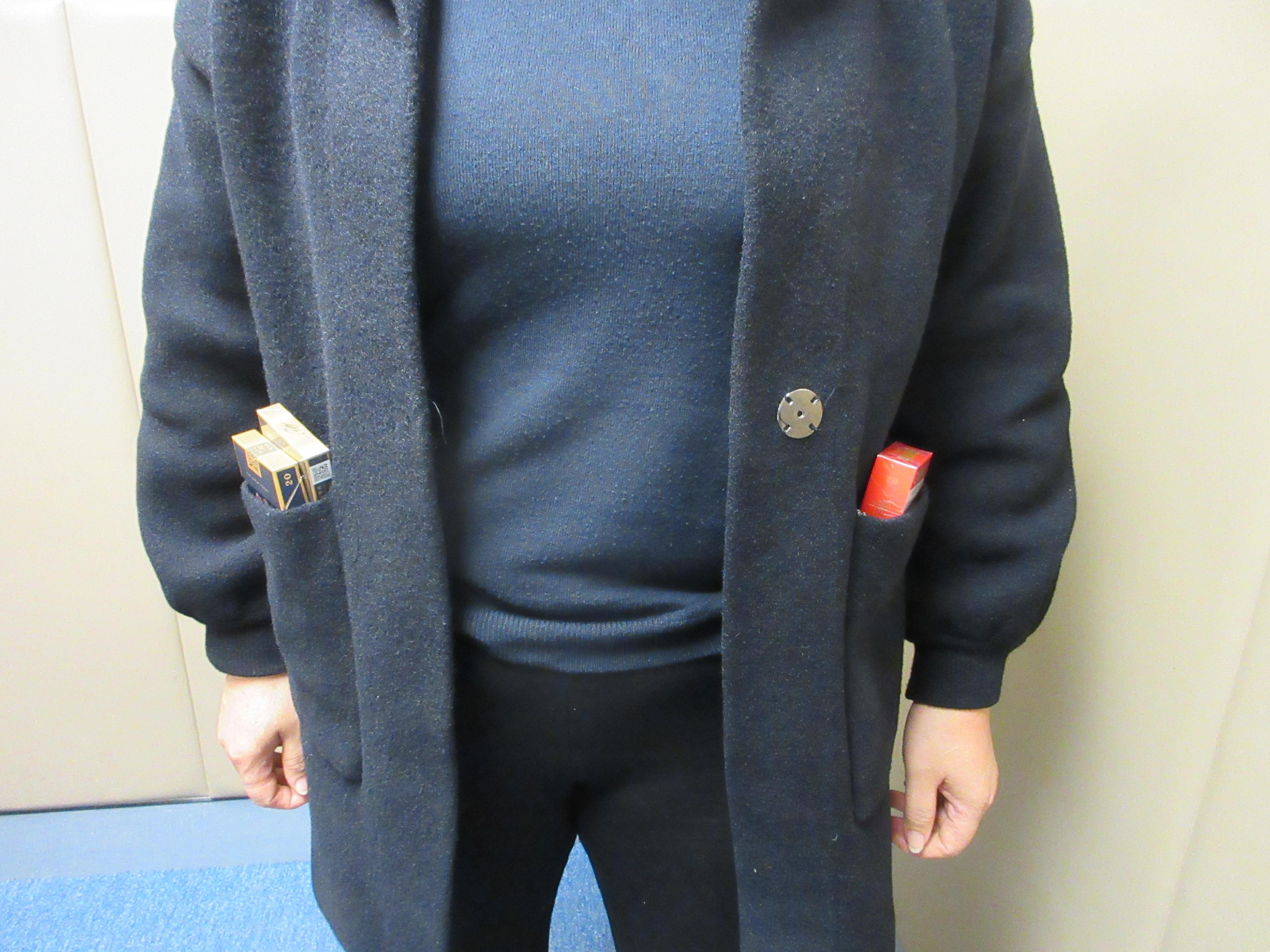 Two incoming passengers were sentenced to four months' imprisonment with a fine of $1,000, and two months' imprisonment respectively by the Fanling Magistrates' Courts today (January 19) for possessing duty-not-paid cigarettes and failing to declare them to Customs officers, in contravention of the Dutiable Commodities Ordinance. Photo shows one passenger concealing the duty-not-paid cigarettes in the pockets of her jacket.
